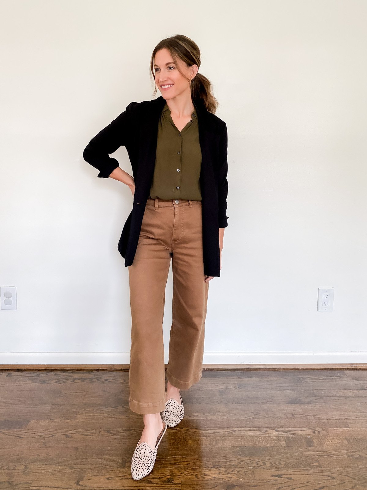 ashley wearing a olive button down, black blazer, brown wide leg crop pants and leopard mules