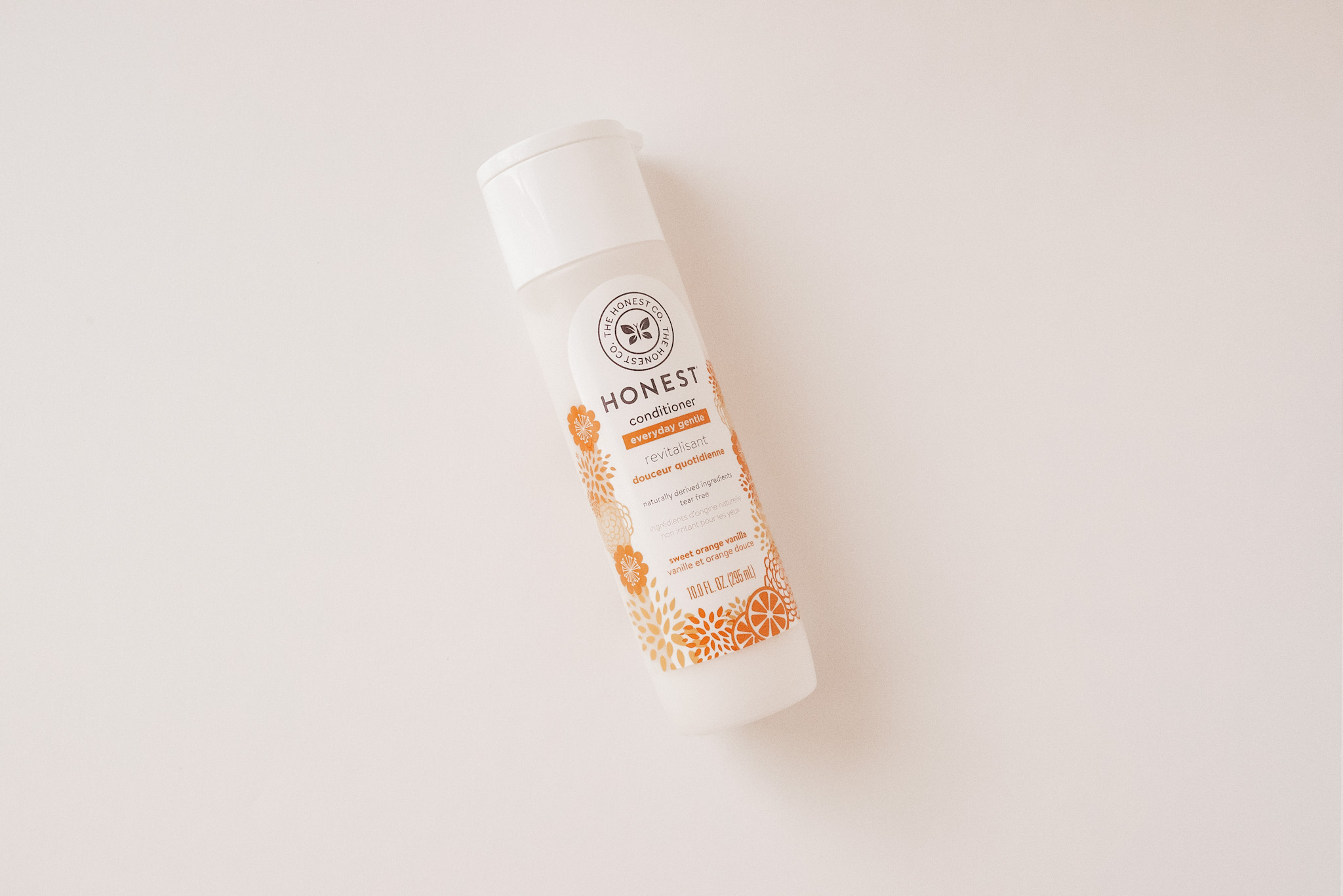 a clear bottle of The Honest Co. conditioner on a white background