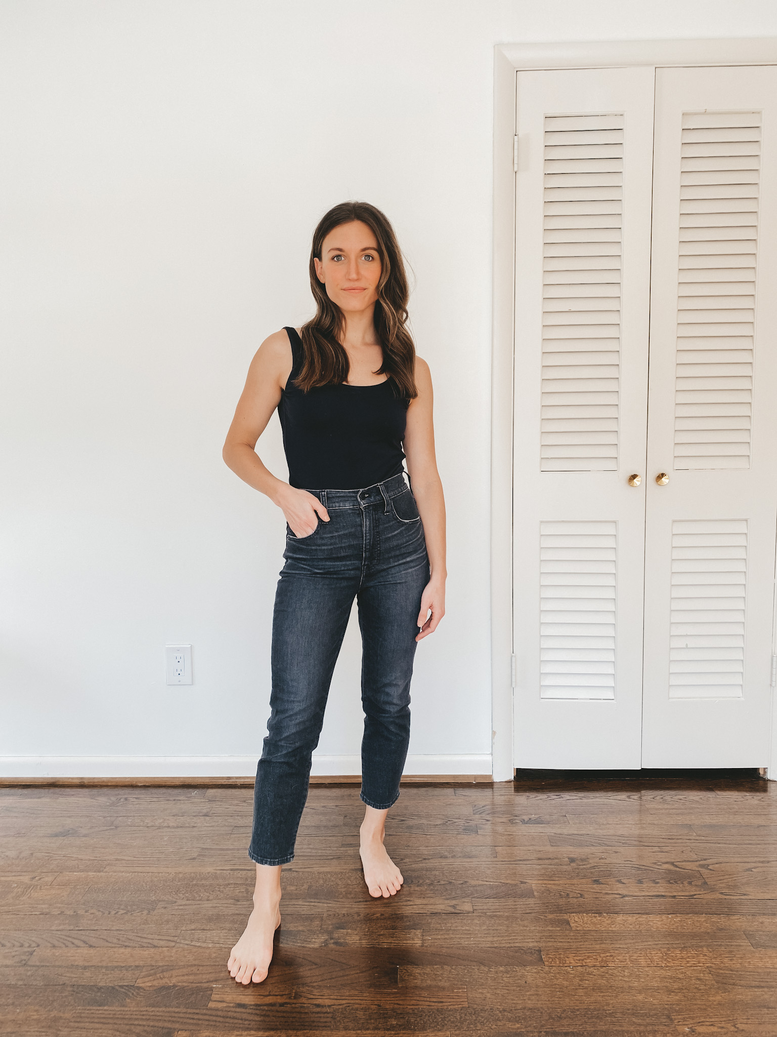 ashley wearing a black Everlane bodysuit and washed black Perfect Vintage Jeans from Madewell