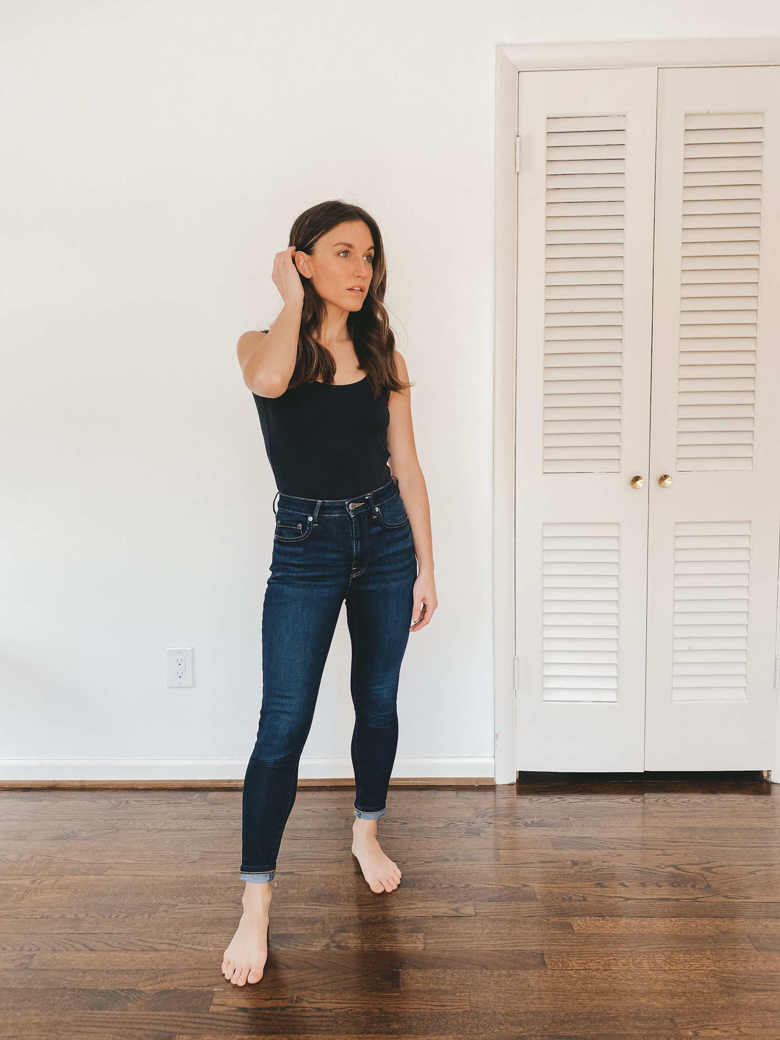 ashley wearing an Everlane black sleeveless bodysuit and deep indigo Authentic Stretch High Rise Skinny Jeans from Everlane