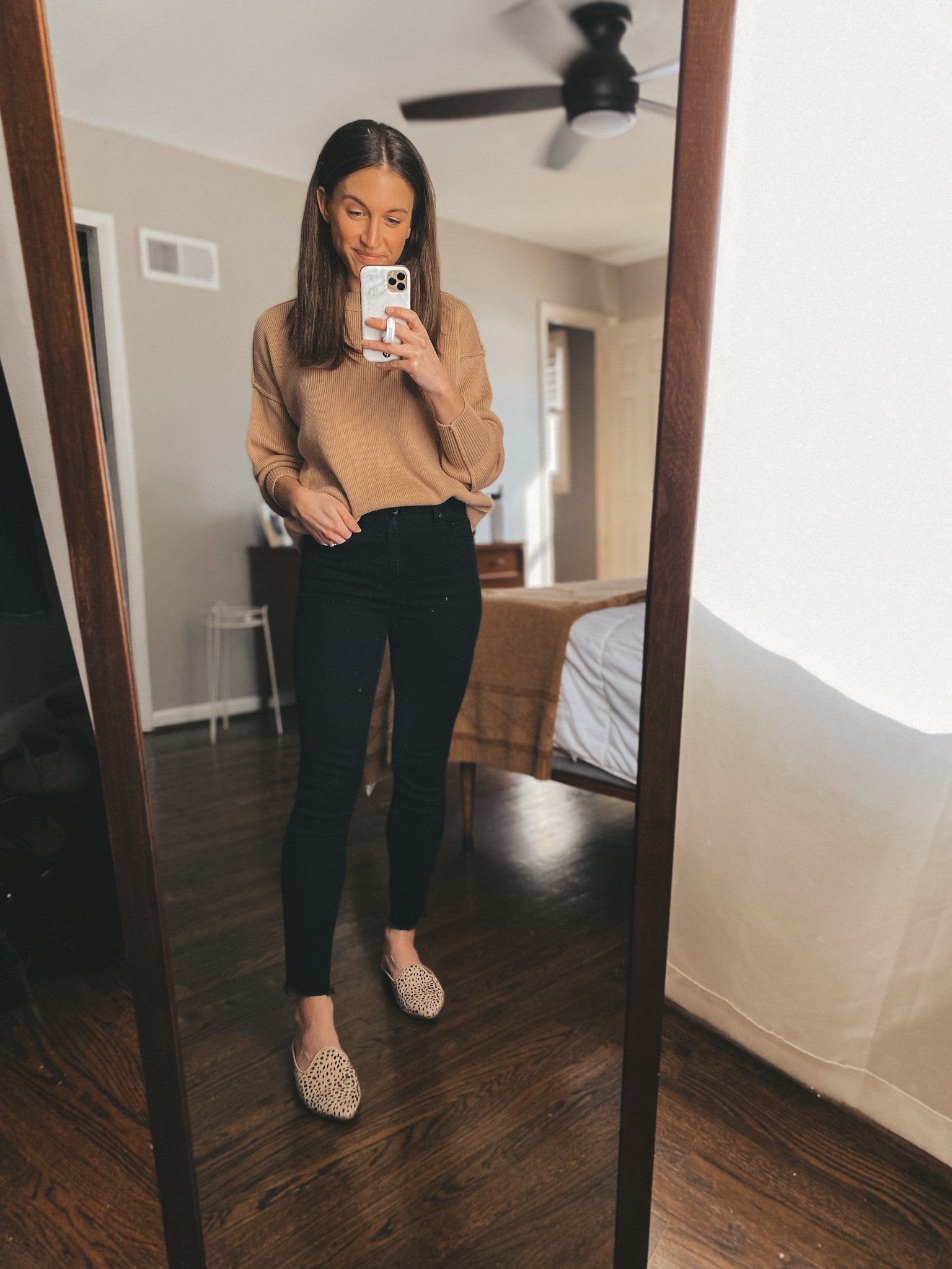 ashley wearing an oversized tan sweater from Abercrombie, black skinny jeans from Everlane and leopard mules from Target