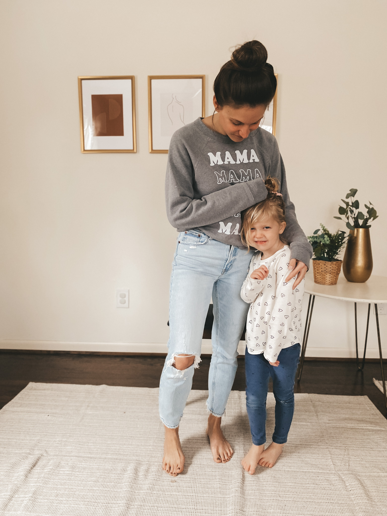 ashley wearing distressed light wash jeans from Abercrombie and a great sweatshirt that says MAMA, she is hugging her daughter
