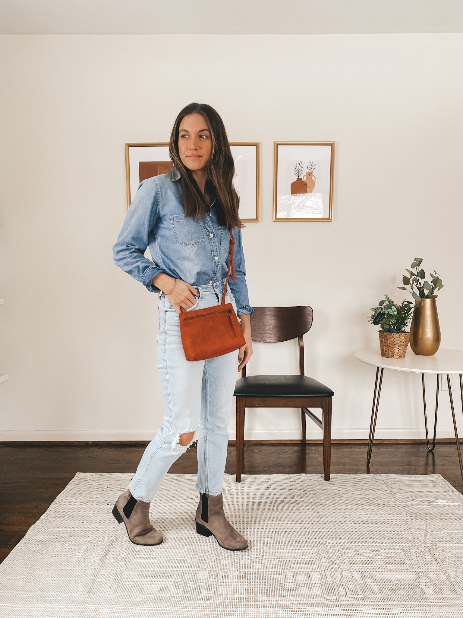 ashley wearing a chambray button down from J.Crew, light wash distressed mom jeans from Abercrombie, brown Chelsea boots from Target and a red crossbody bag from Target