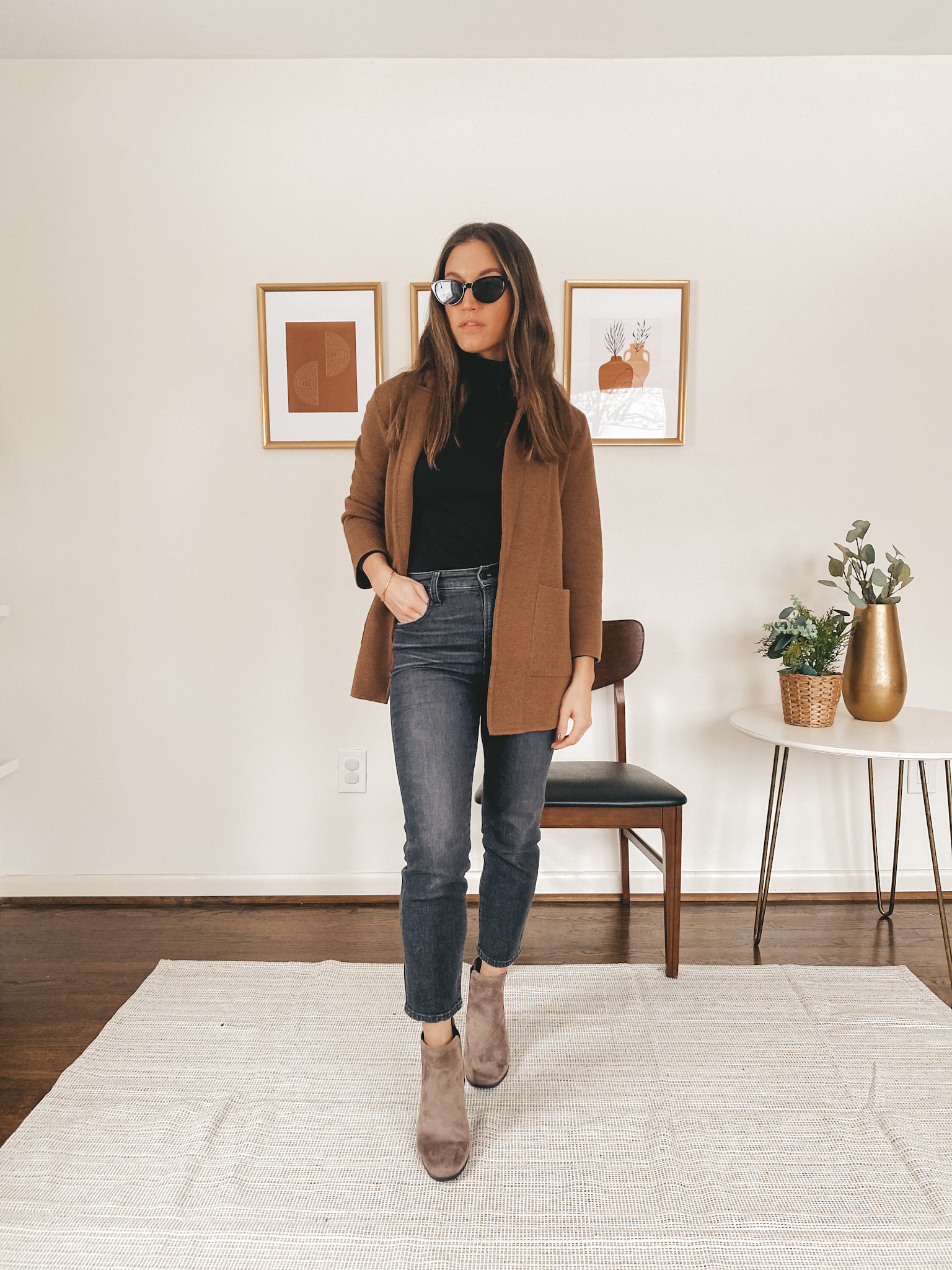 ashley wearing a black turtleneck from J.Crew, a brown sweater blazer from J.Crew, washed black vintage jeans from Madewell, brown Chelsea boots from Target, and black cat eye sunglasses from Target