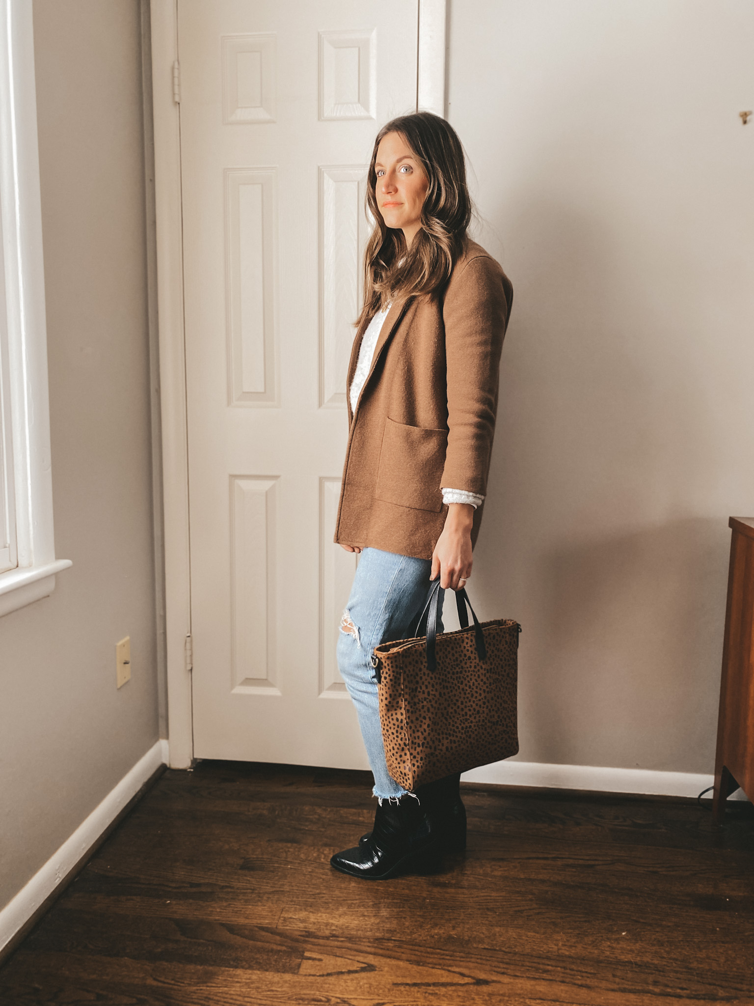 ashley wearing a light gray sweater, brown sweater blazer from J.Crew, light wash straight leg jeans from Madewell and black boots from Target