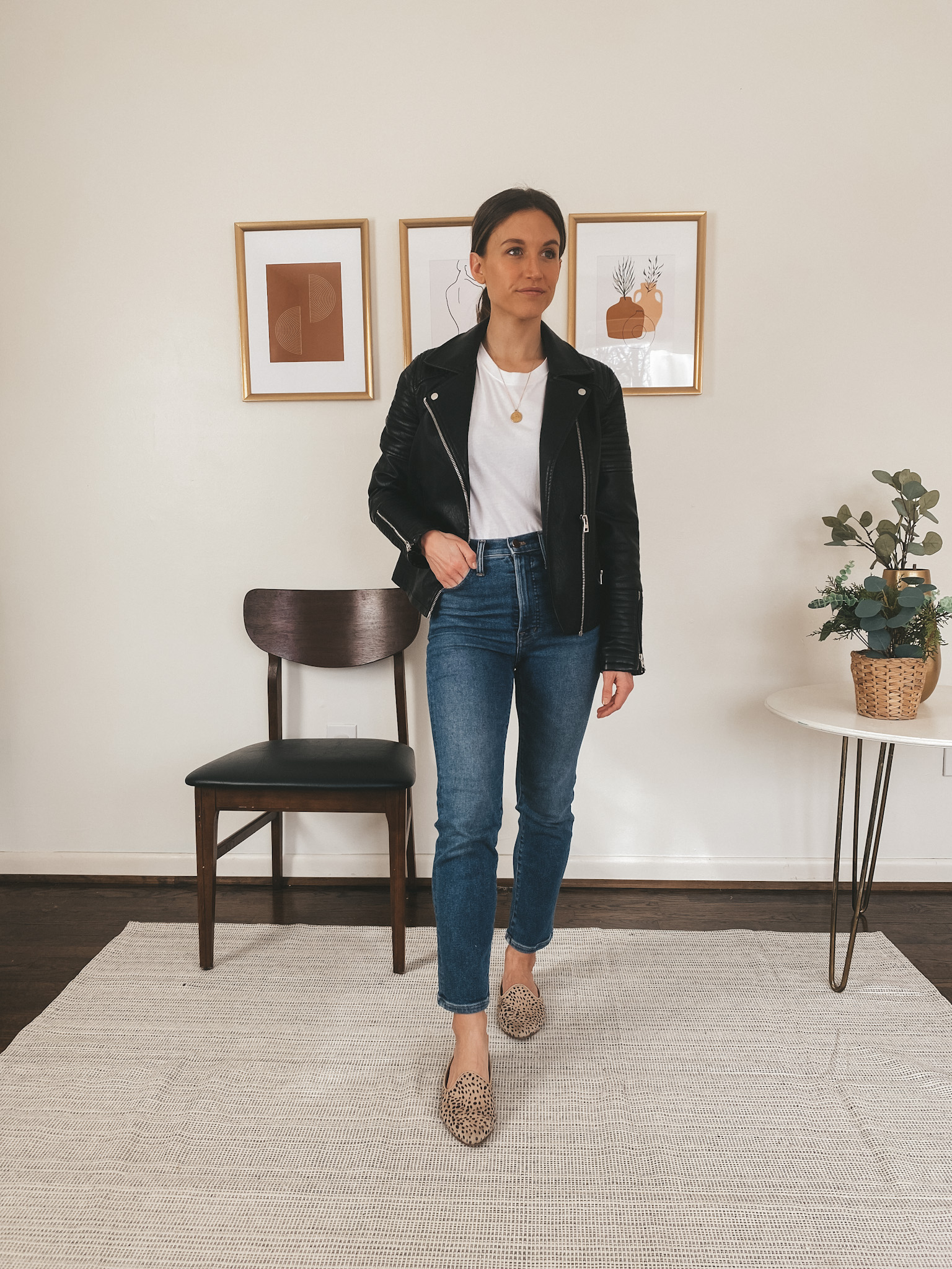 ashley wearing a Top Shop faux leather jacket, an Everlane white tee, Madewell Perfect Vintage Jeans, and Target leopard mules