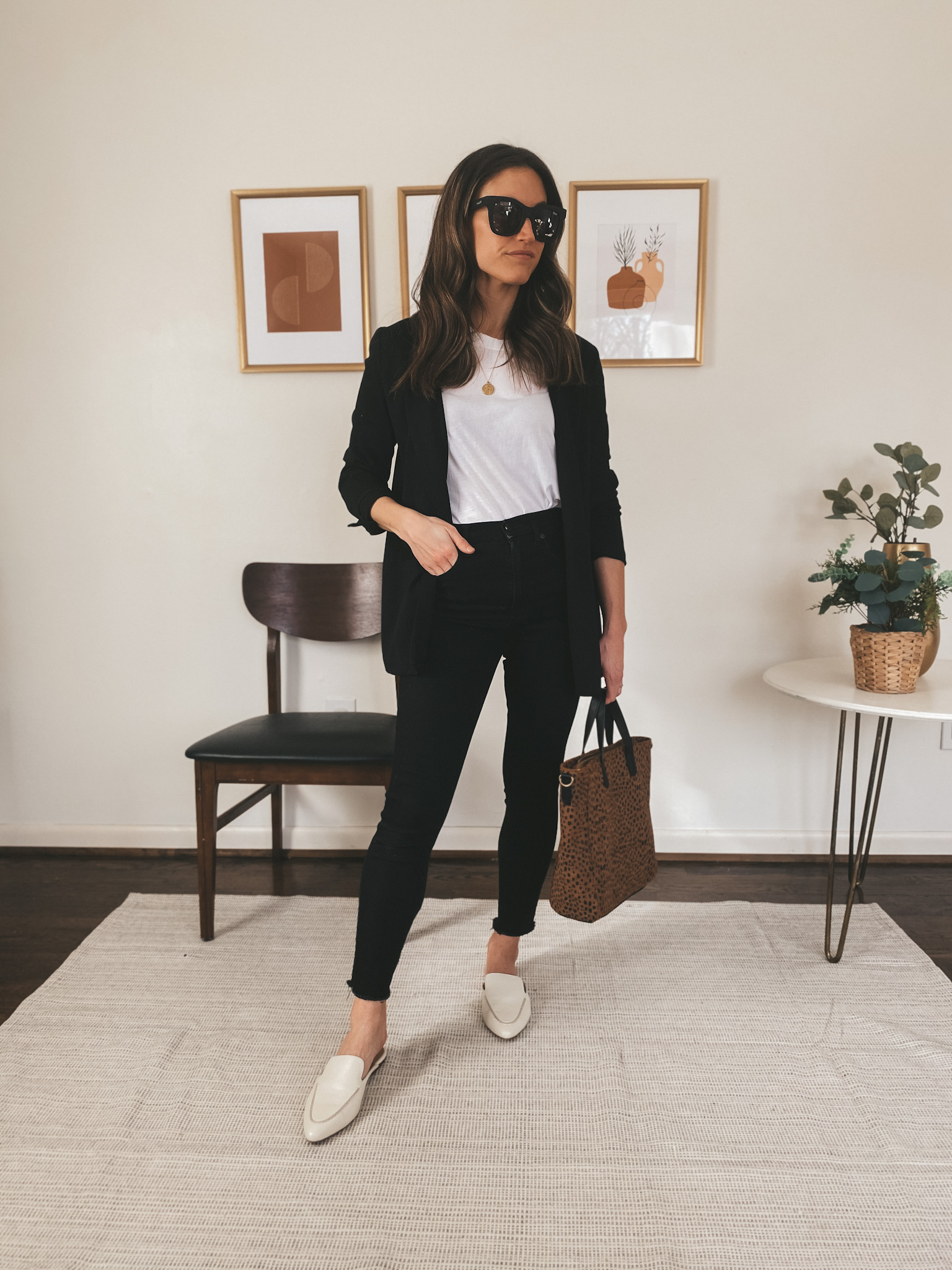 ashley wearing a black Old Navy boyfriend blazer, an Everlane white tee, Everlane high rise skinny jeans in black, white mules from Everlane, and a leopard Tote bag and black square frame Quay sunglasses