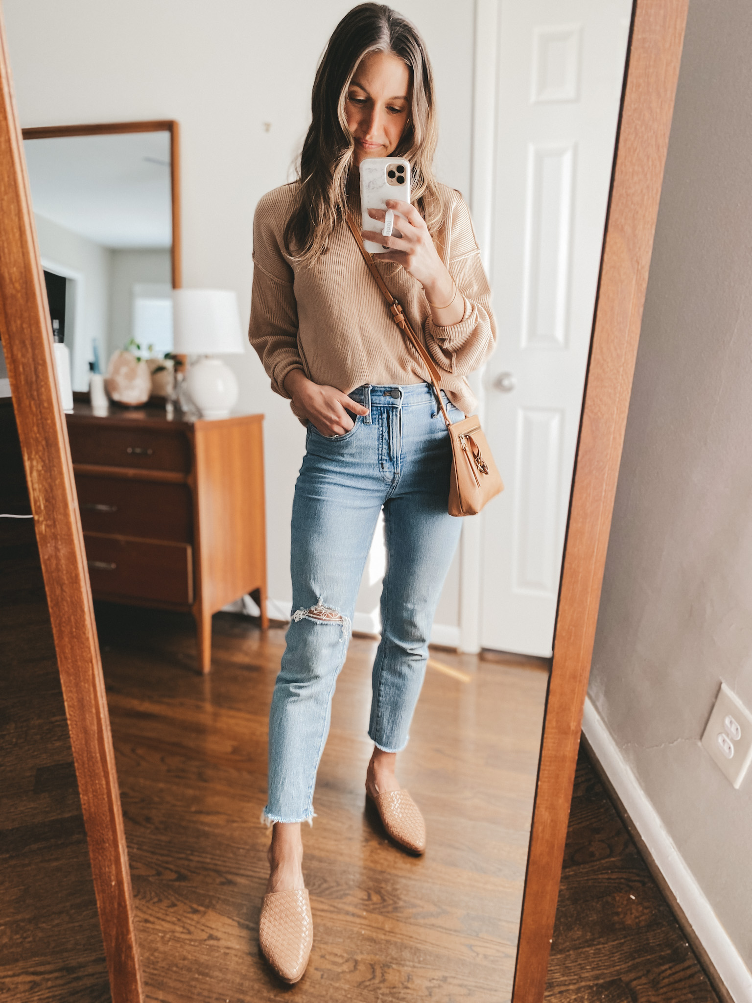 ashley wearing Madewell Perfect Vintage Jeans, an Abercrombie oversized ribbed sweater in tan, Marc Fisher woven mules, and a Target camel crossbody bag