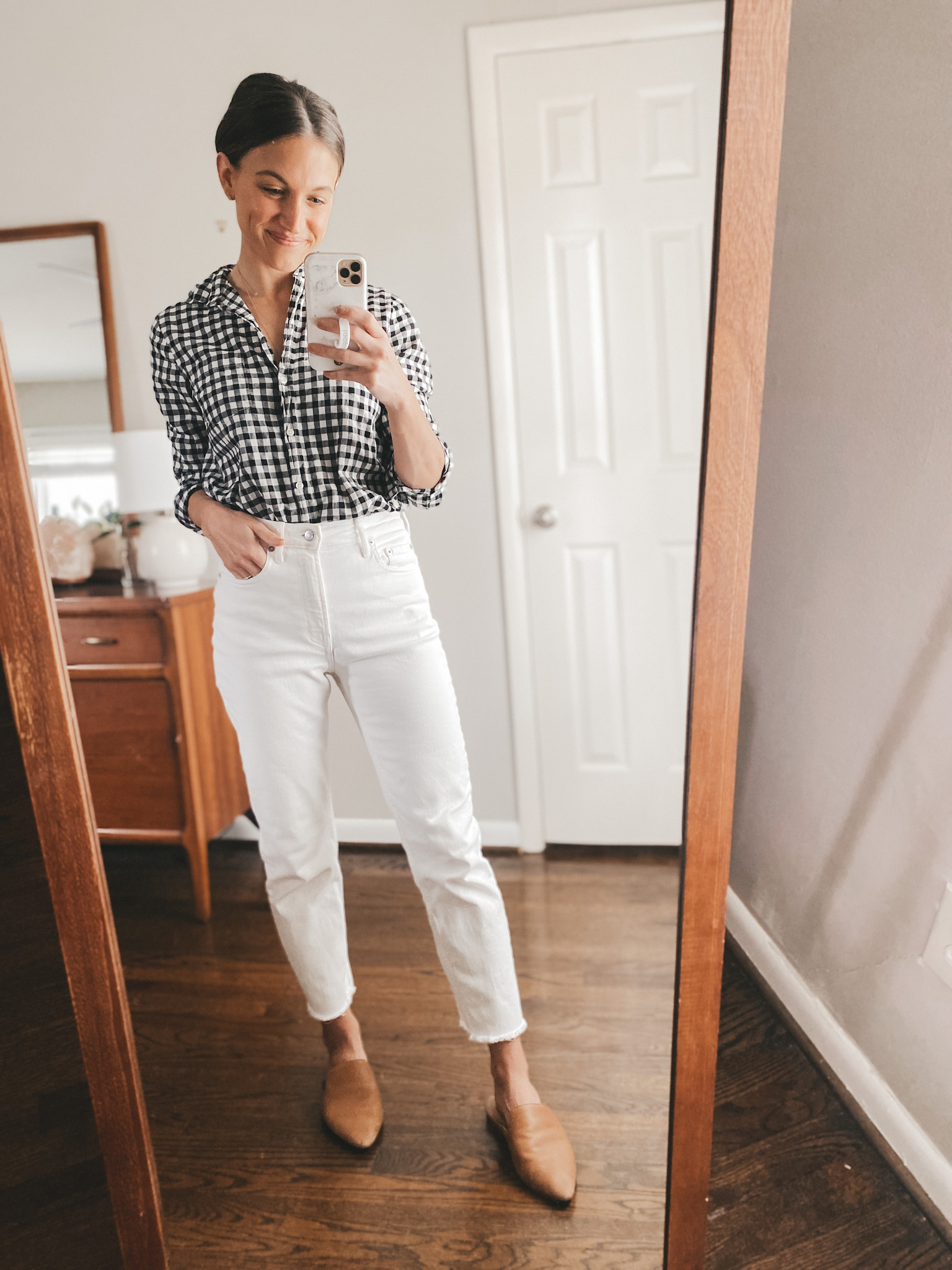 ashley wearing a J.Crew gingham button down, white Everlane straight leg jeans, and cognac mules