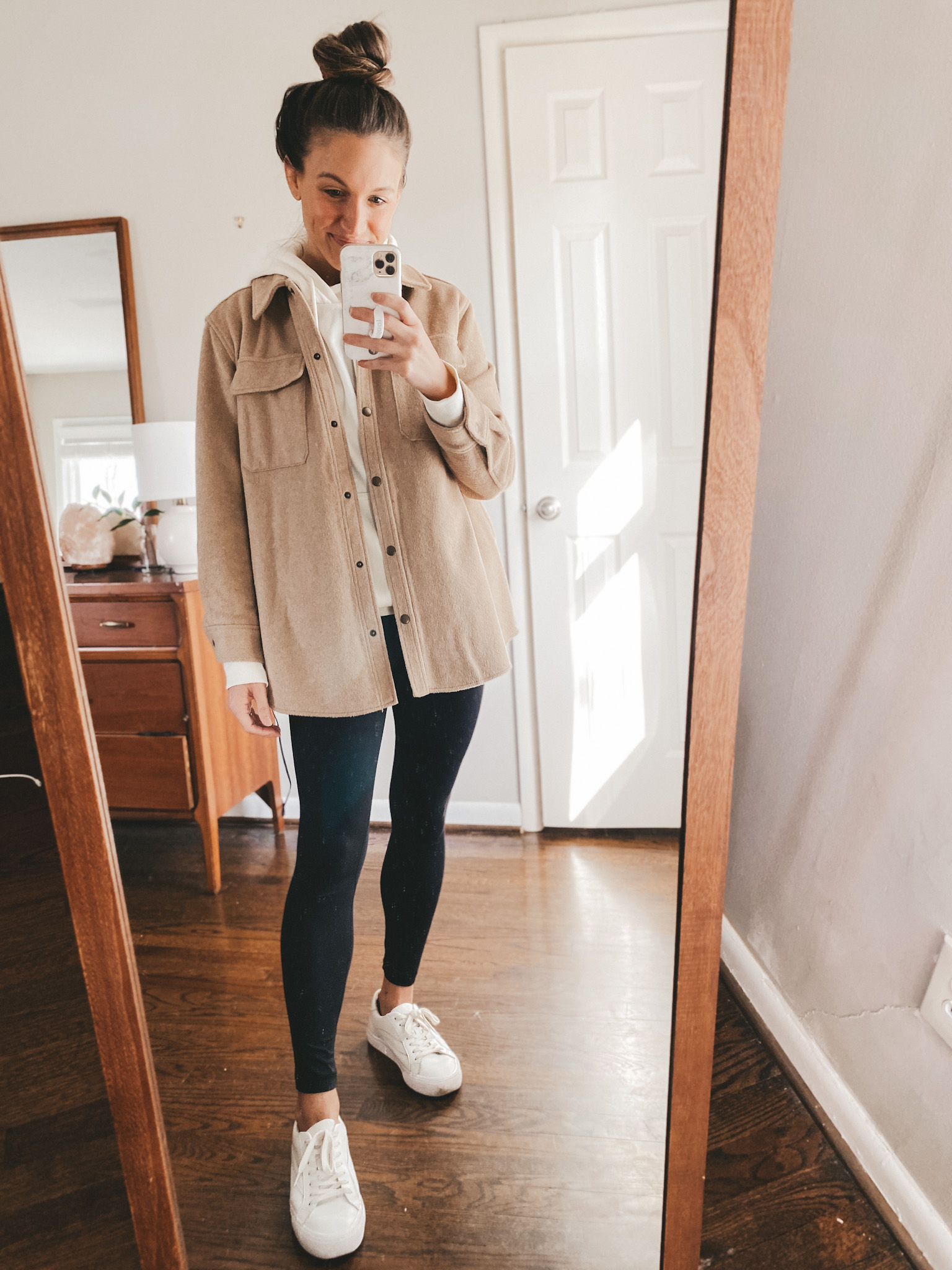 ashley wearing an H&M cream hoodie under an Old Navy tan shacket, black CRZ Yoga leggings, and white Madewell sneakers