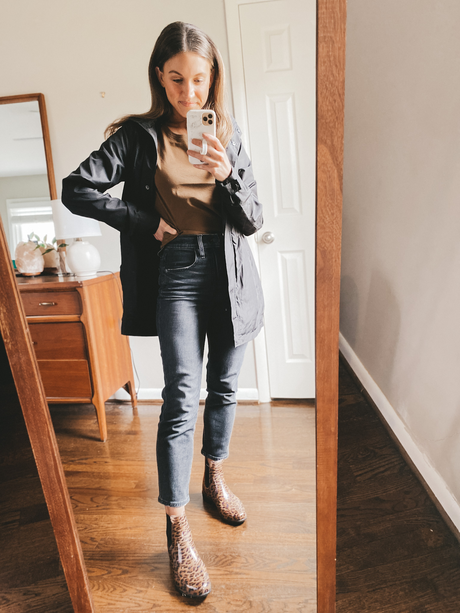 ashley wearing an Everlane Walnut tee, a Target black rain jacket, Madewell Perfect Vintage jeans in washed black, and Target leopard print rain boots