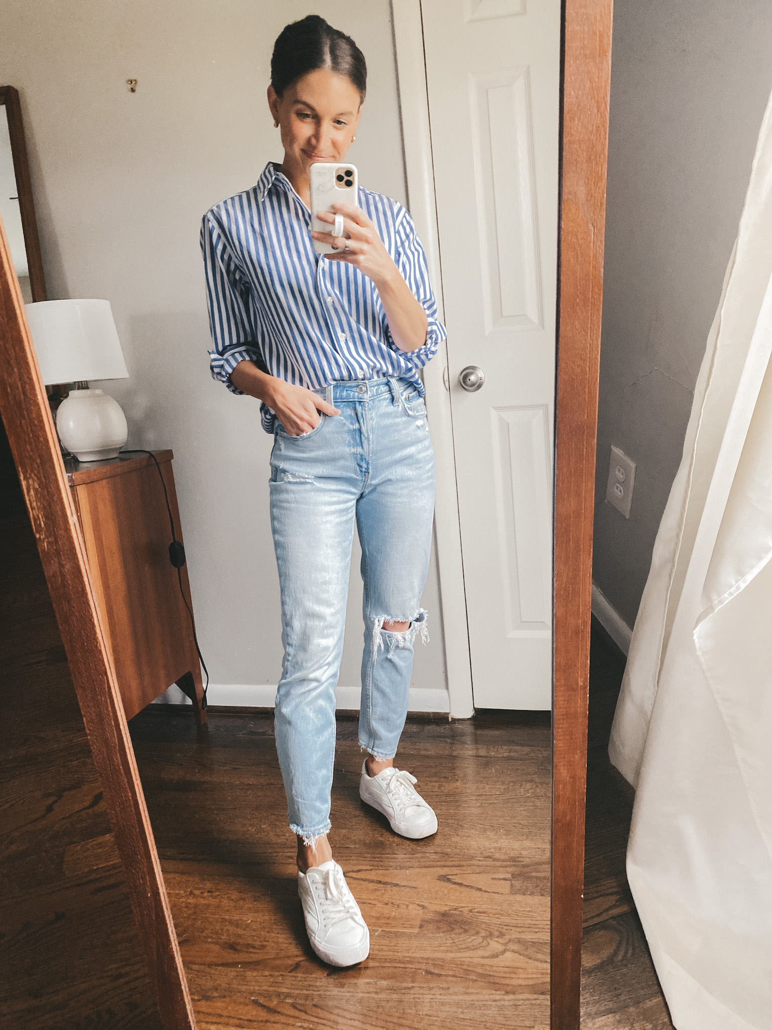 ashley wearing a Walmart blue and white striped button down, Abercrombie mom jeans, and Madewell white sneakers