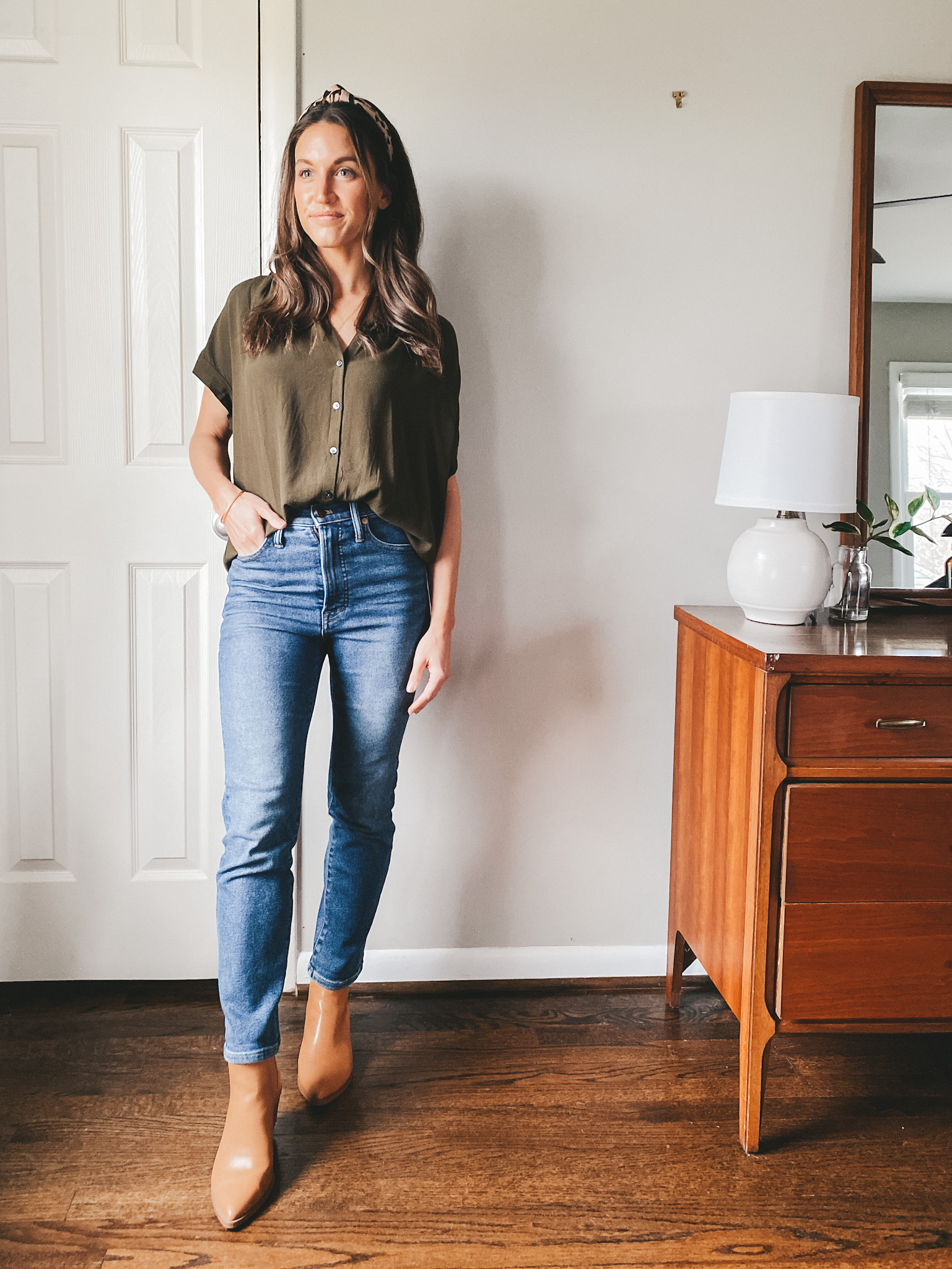 ashley wearing a Madewell green drapey button down, Madewell perfect vintage jeans, and Target camel ankle booties, and a leopard headband
