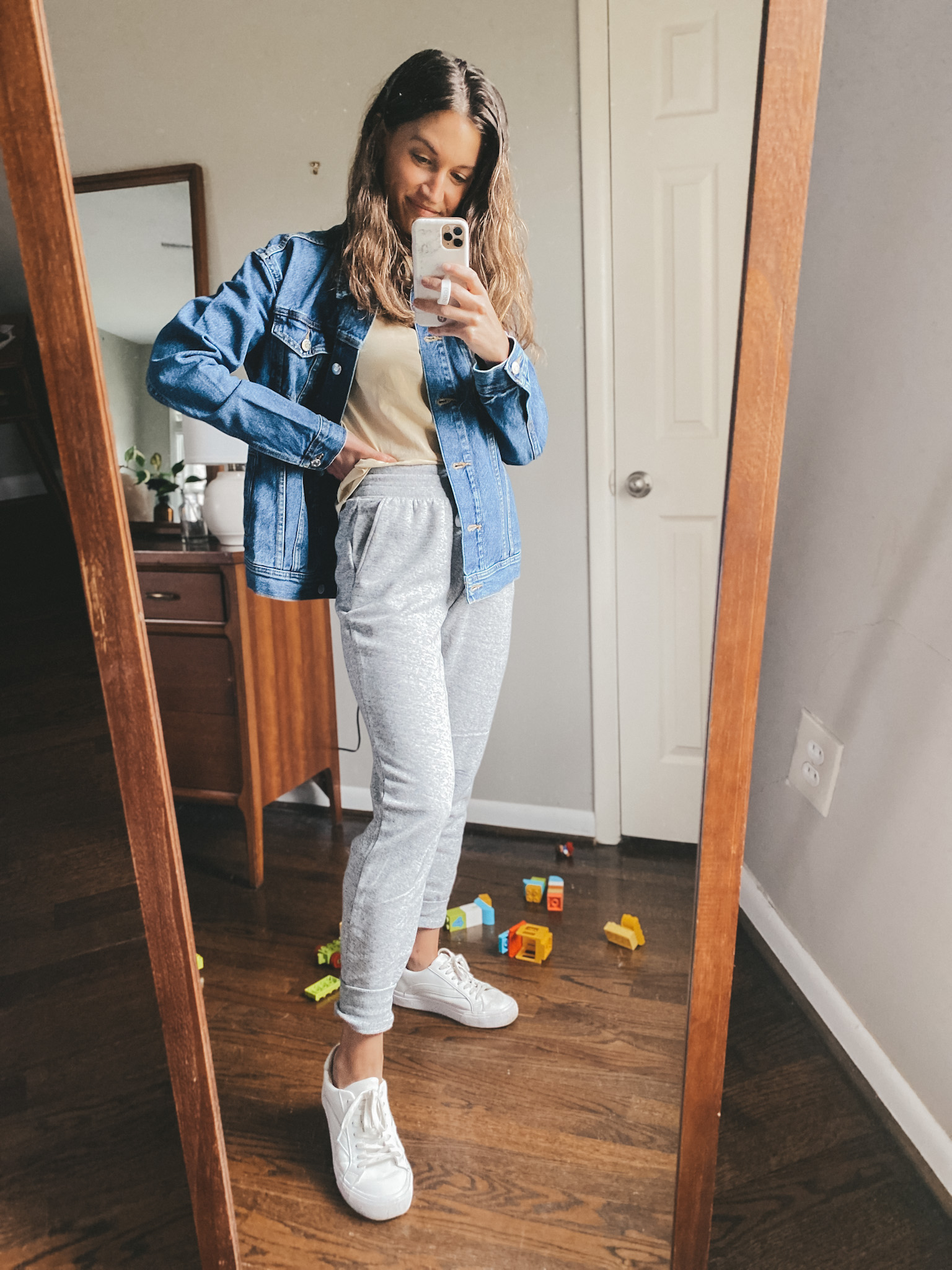 ashley wearing an Everlane tan colored tee, an Old Navy jean jacket, Old Navy joggers, and Madewell white sneakers