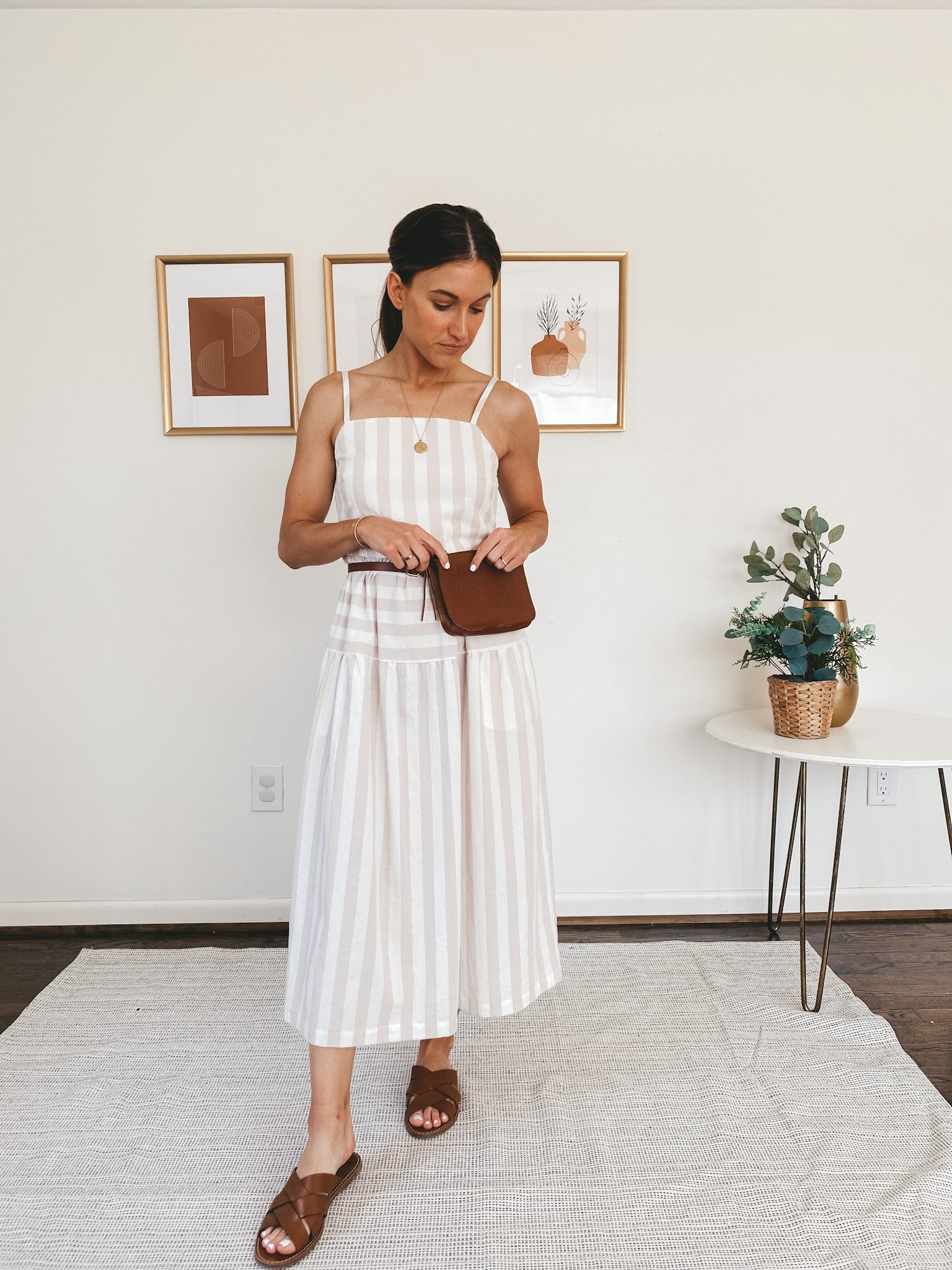 ashley wearing a tan and white striped midi dress from Target, Madewell slip on sandals and a Madewell brown belt bag