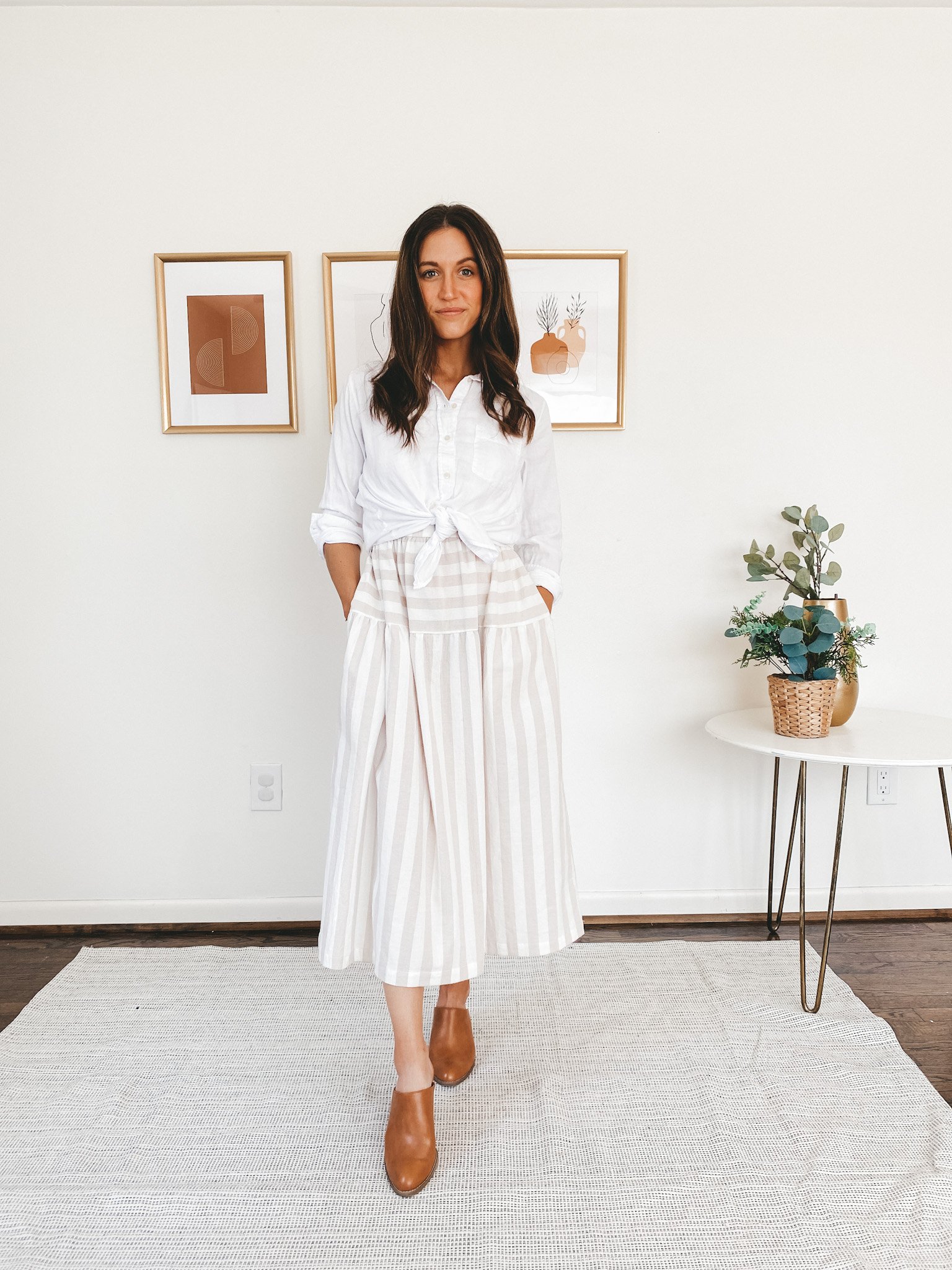 ashley wearing an Everlane white button down, a Target tan and white striped midi dress, and brown heeled mules