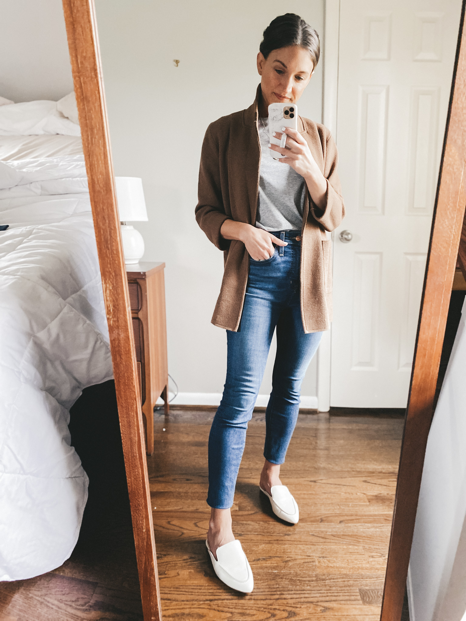 ashley wearing a gray tee, brown sweater blazer, skinny jeans and white mules