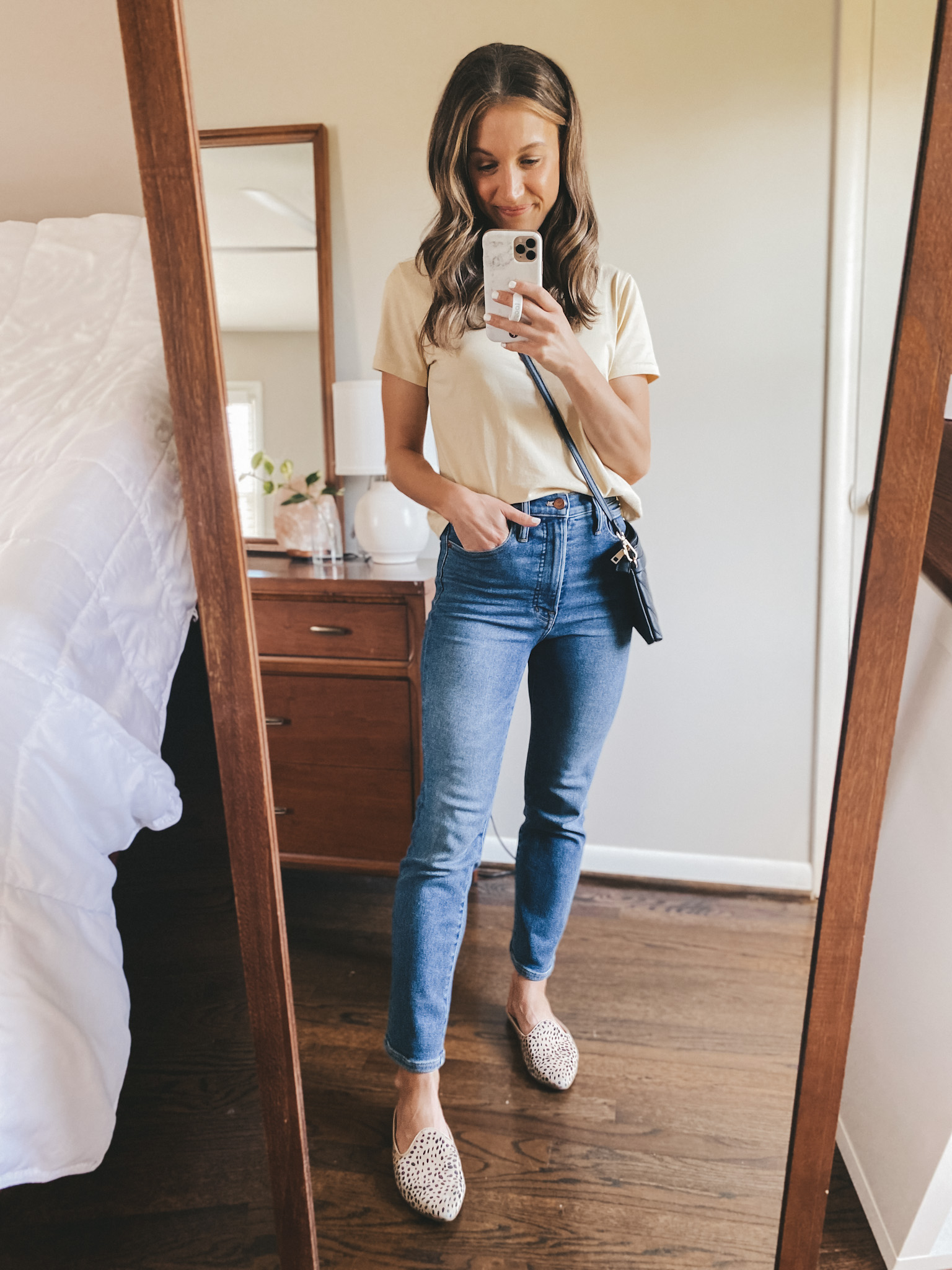 ashley wearing a tan colored tee from Everlane, Madewell Perfect Vintage Jeans and Target leopard mules with a black quilted crossbody purse