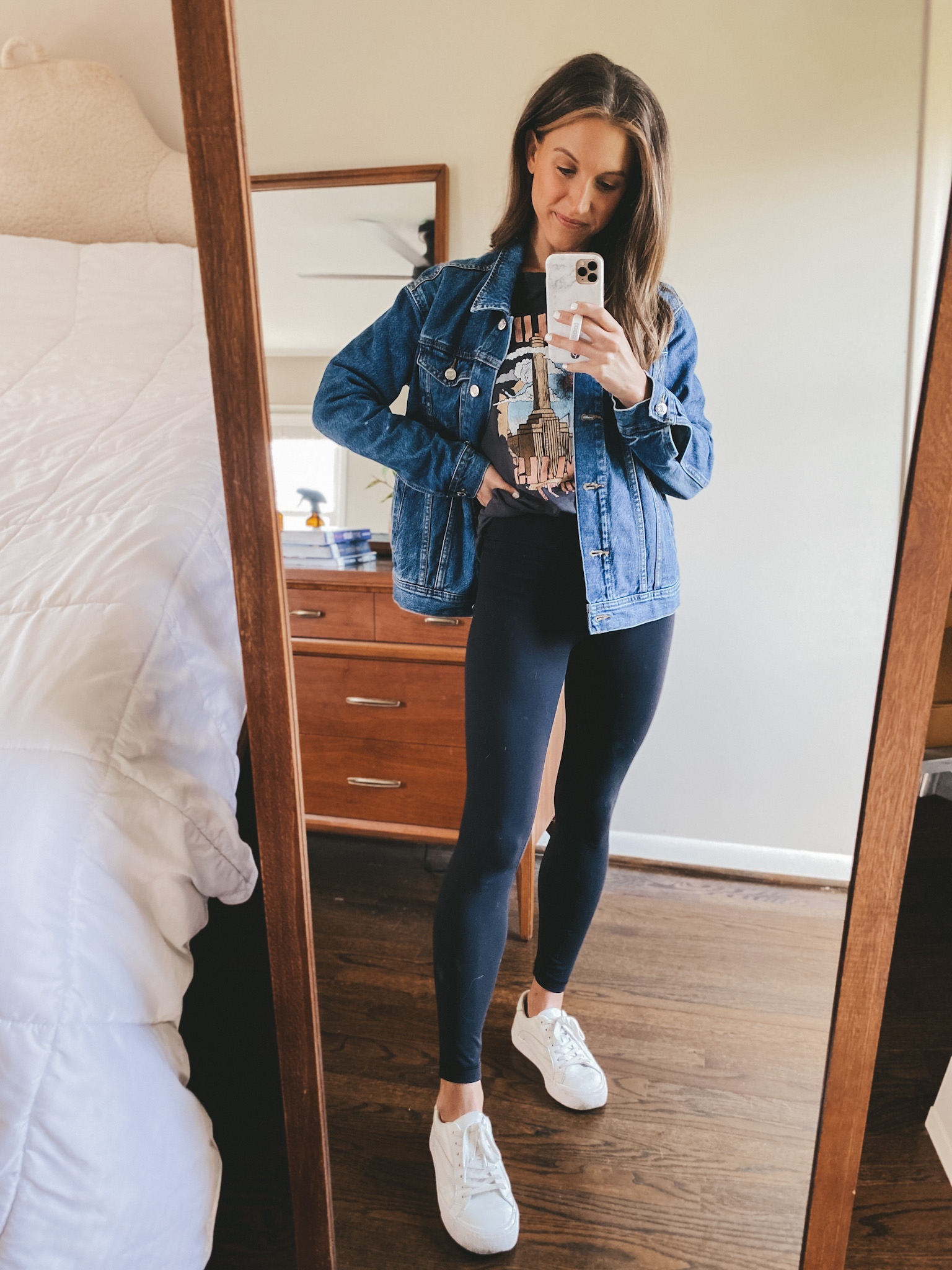 ashley wearing an H&M black band tee, an Old Navy denim jacket, CRZ Leggings and Madewell white sneakers