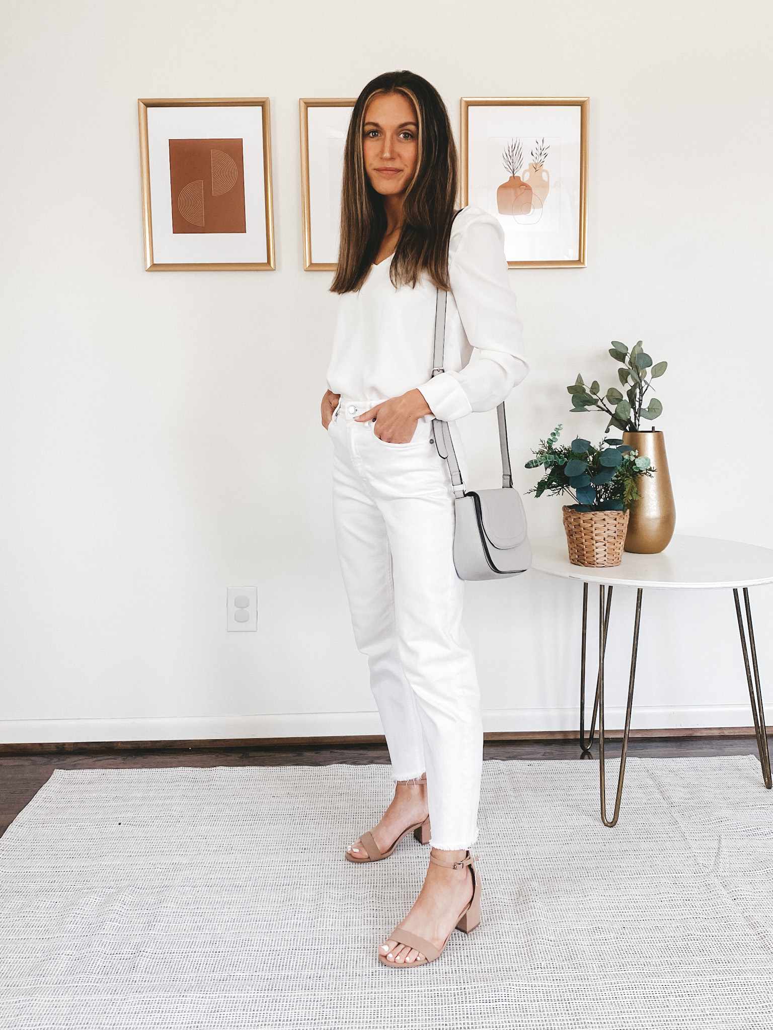 ashley wearing a white blouse, white jeans, and nude colored block heels