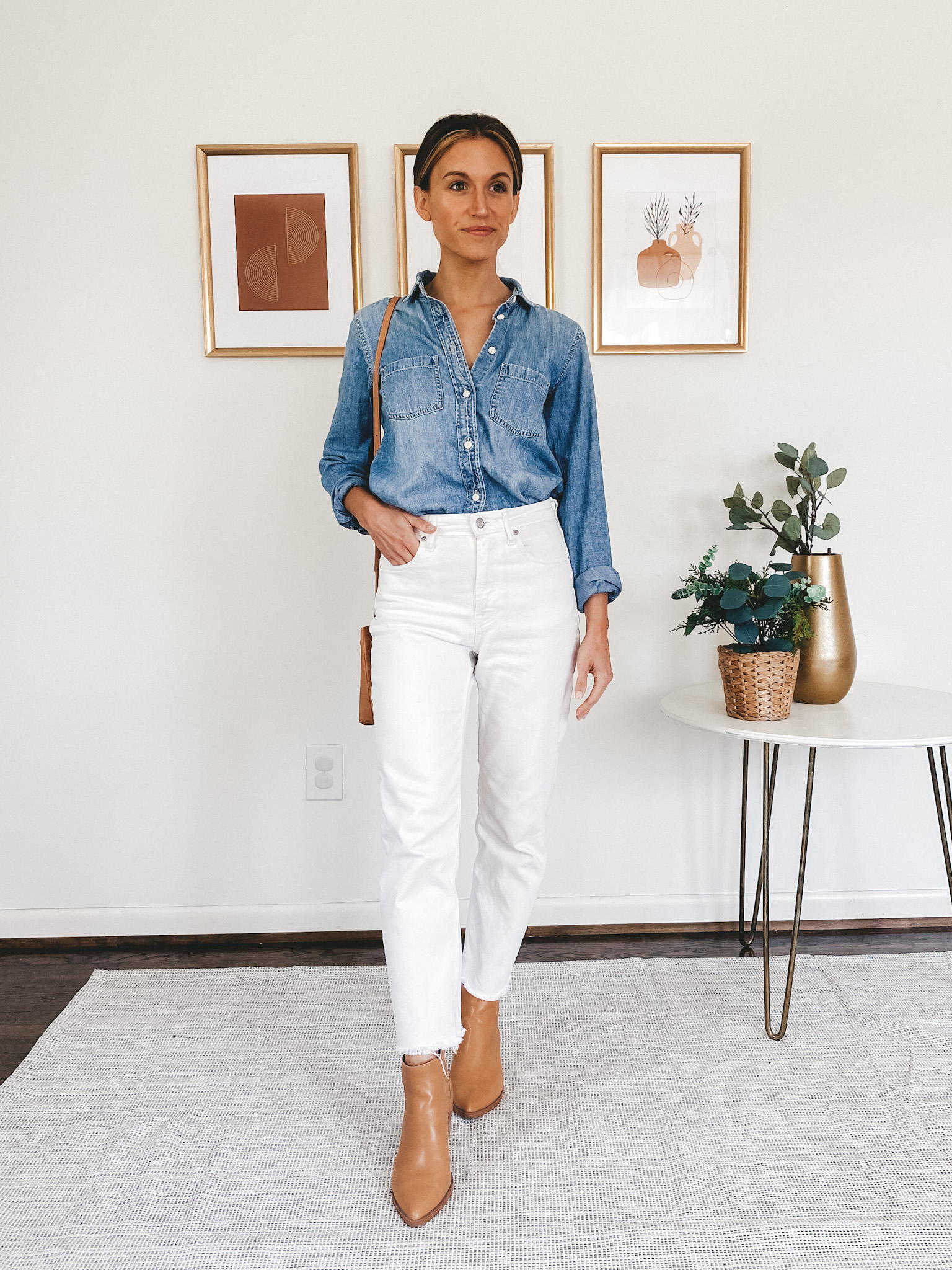 ashley wearing a chambray button down, white denim, and white mules