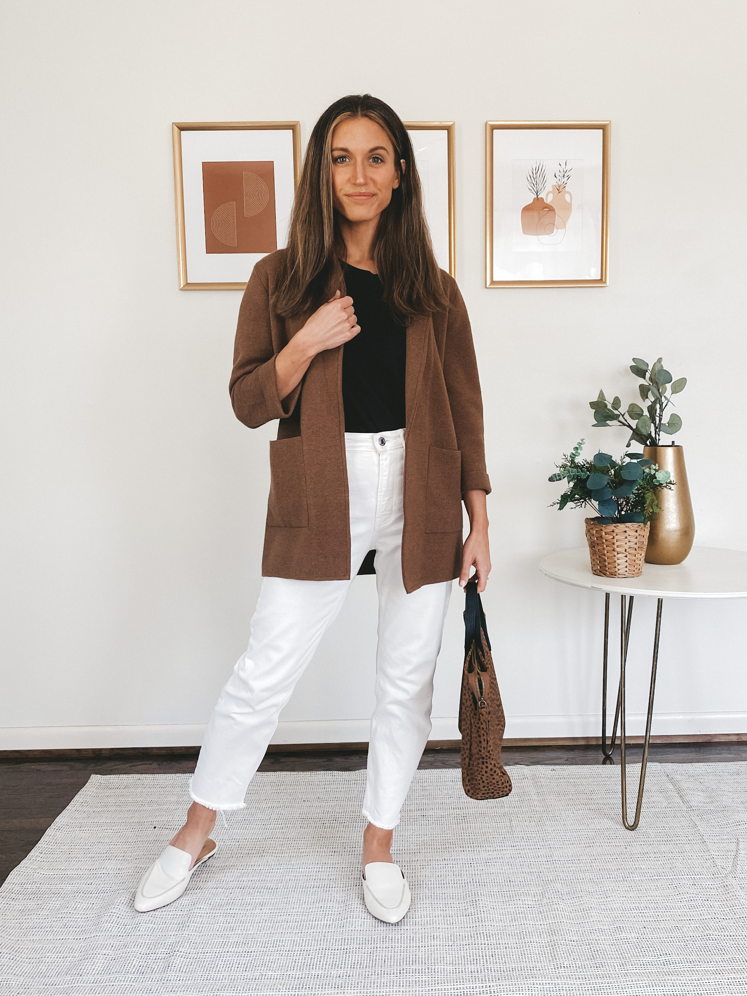 ashley wearing a black tee, brown sweater blazer, white denim and white mules