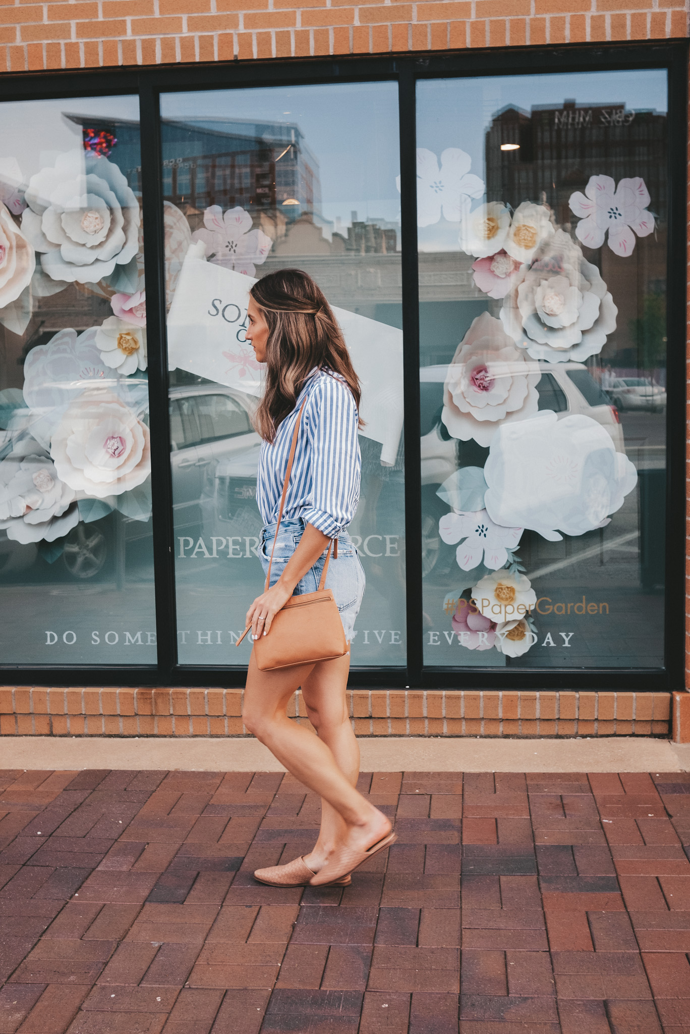 ashley walking along a brick sidewalk in front of a store on the Country Club Plaza in Kansas City