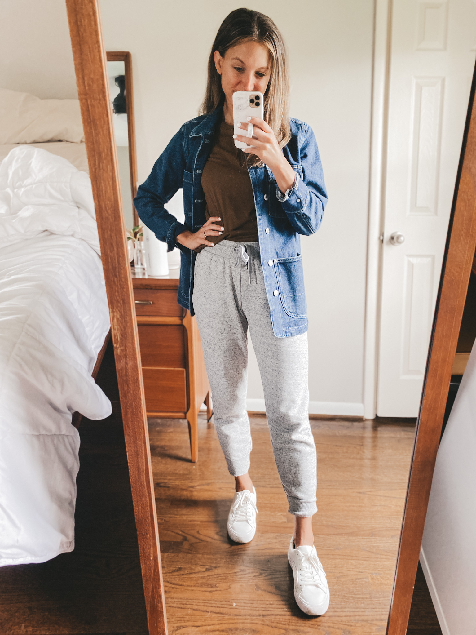ashley wearing a brown tee, denim chore jacket, gray joggers, and white sneakers