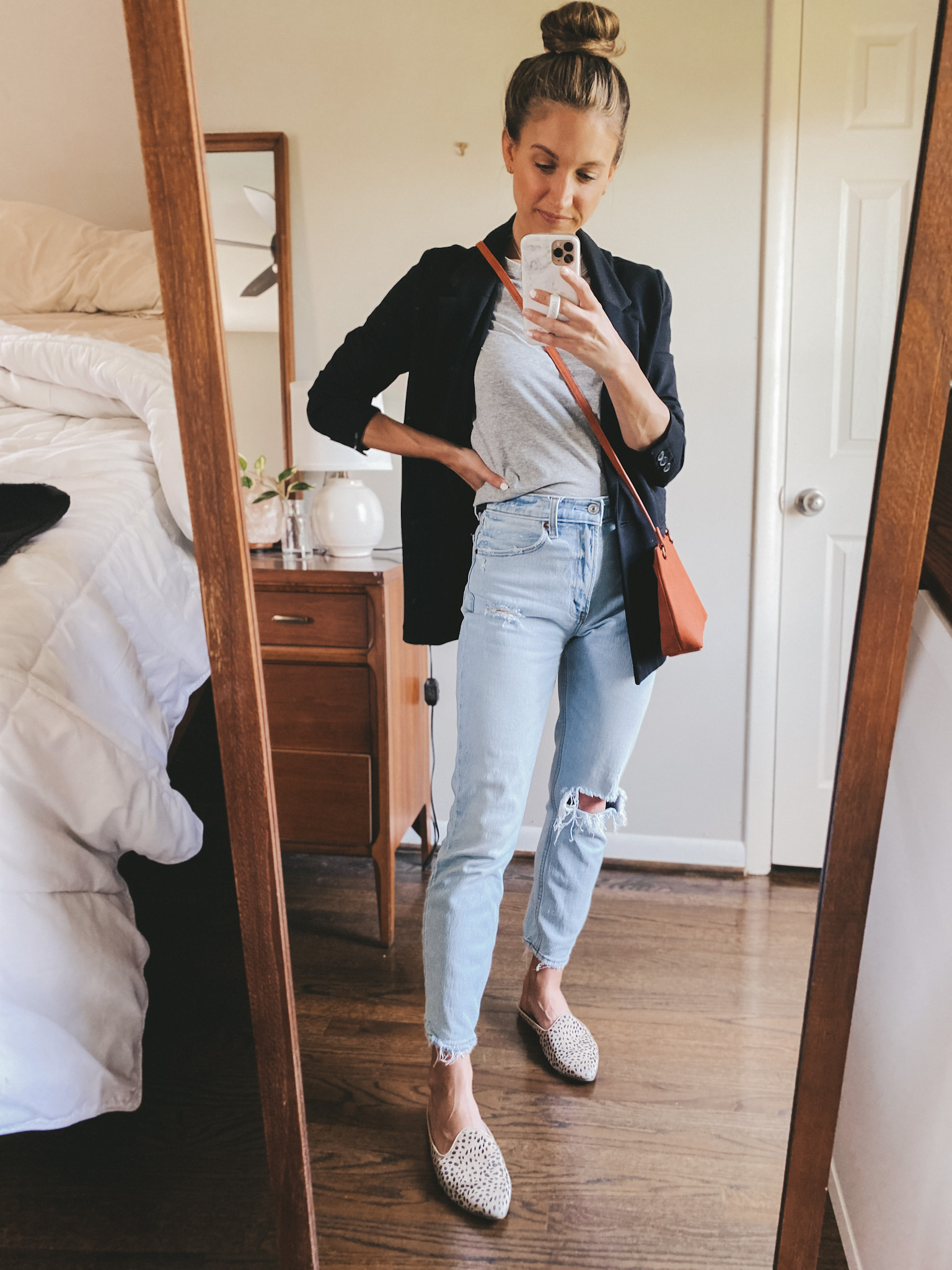ashley wearing a gray tee, black boyfriend blazer, light wash mom jeans, and leopard mules