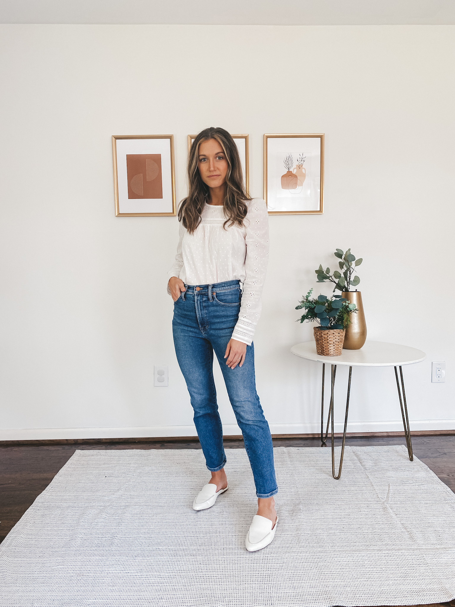 ashley wearing a long-sleeved eyelet top, mid-wash straight leg denim and white mules