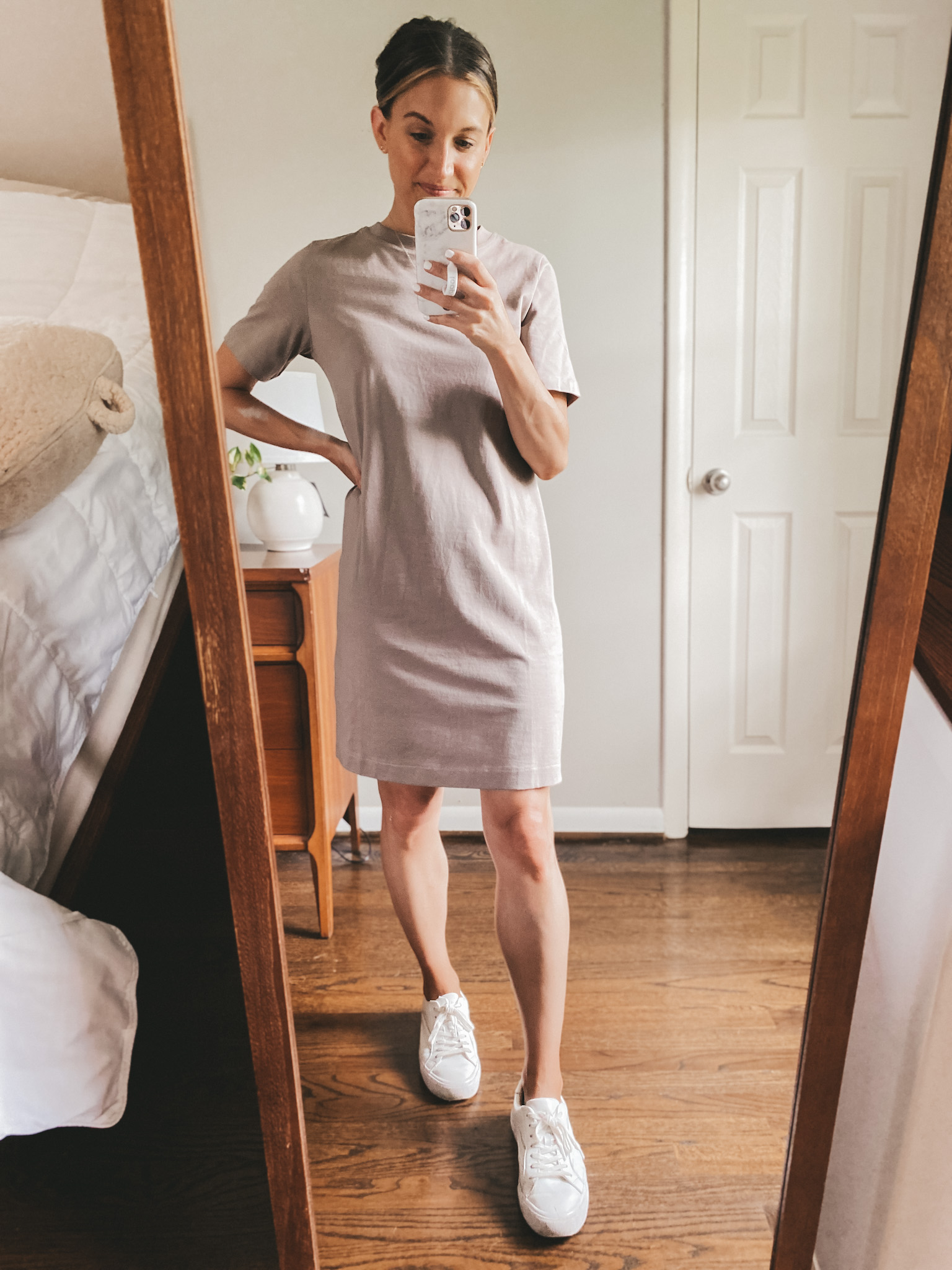 a mirror selfie with ashley wearing a taupe t-shirt dress and white sneakers
