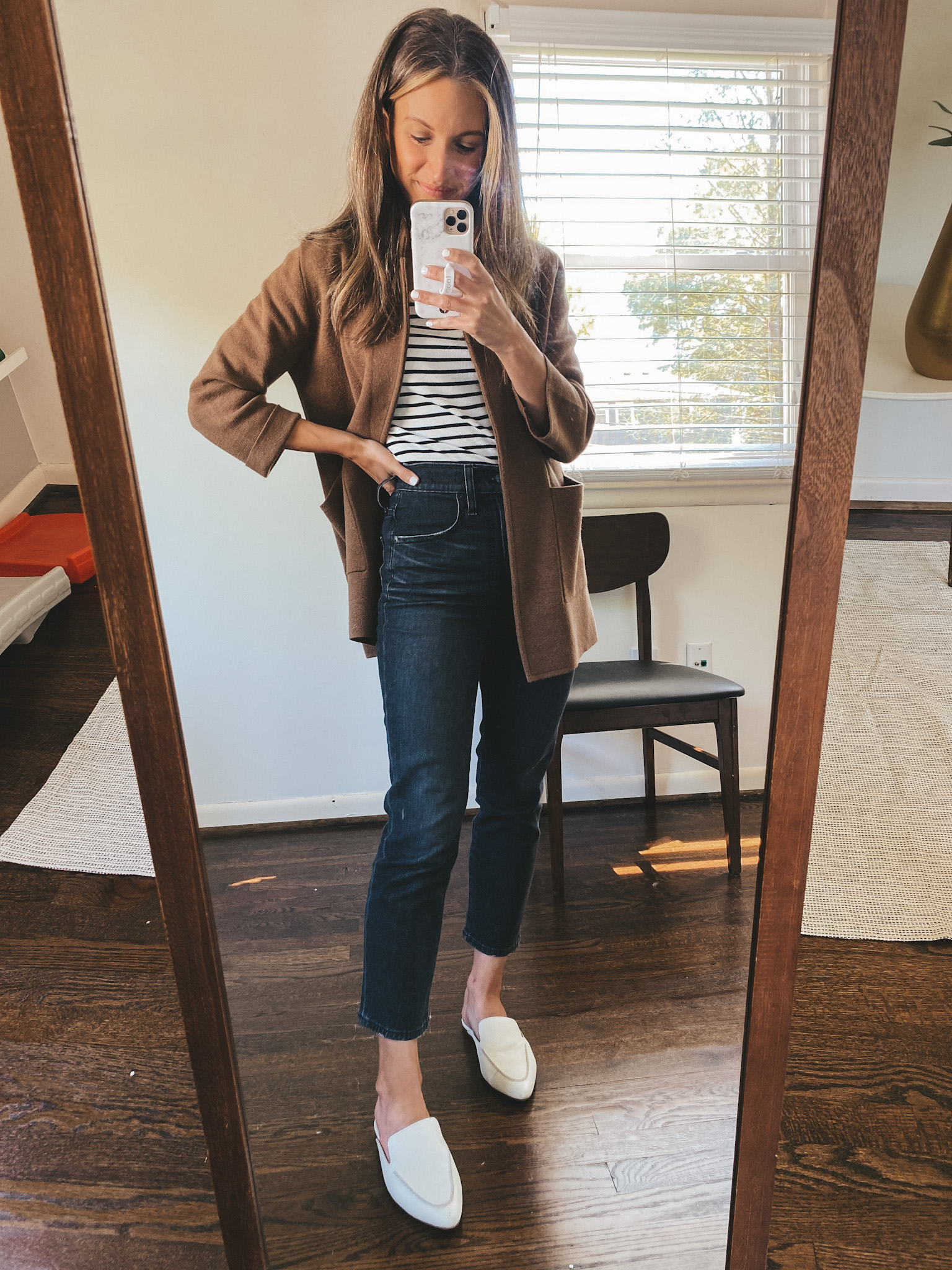 ashley wearing a fitted striped tee, brown sweater blazer, washed black jeans, and white mules