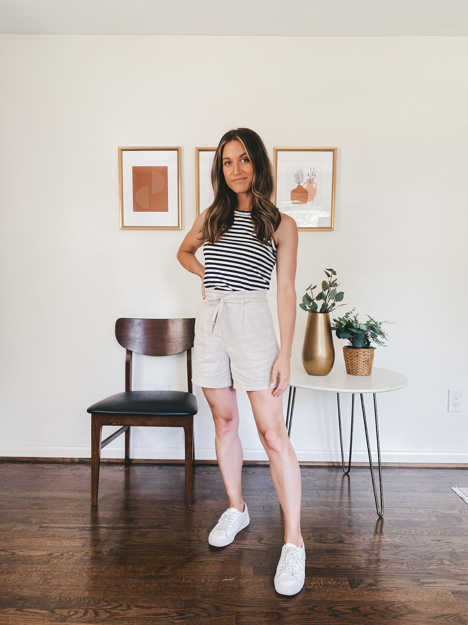 ashley wearing a navy and white striped tank, tan linen blend shorts, and white sneakers