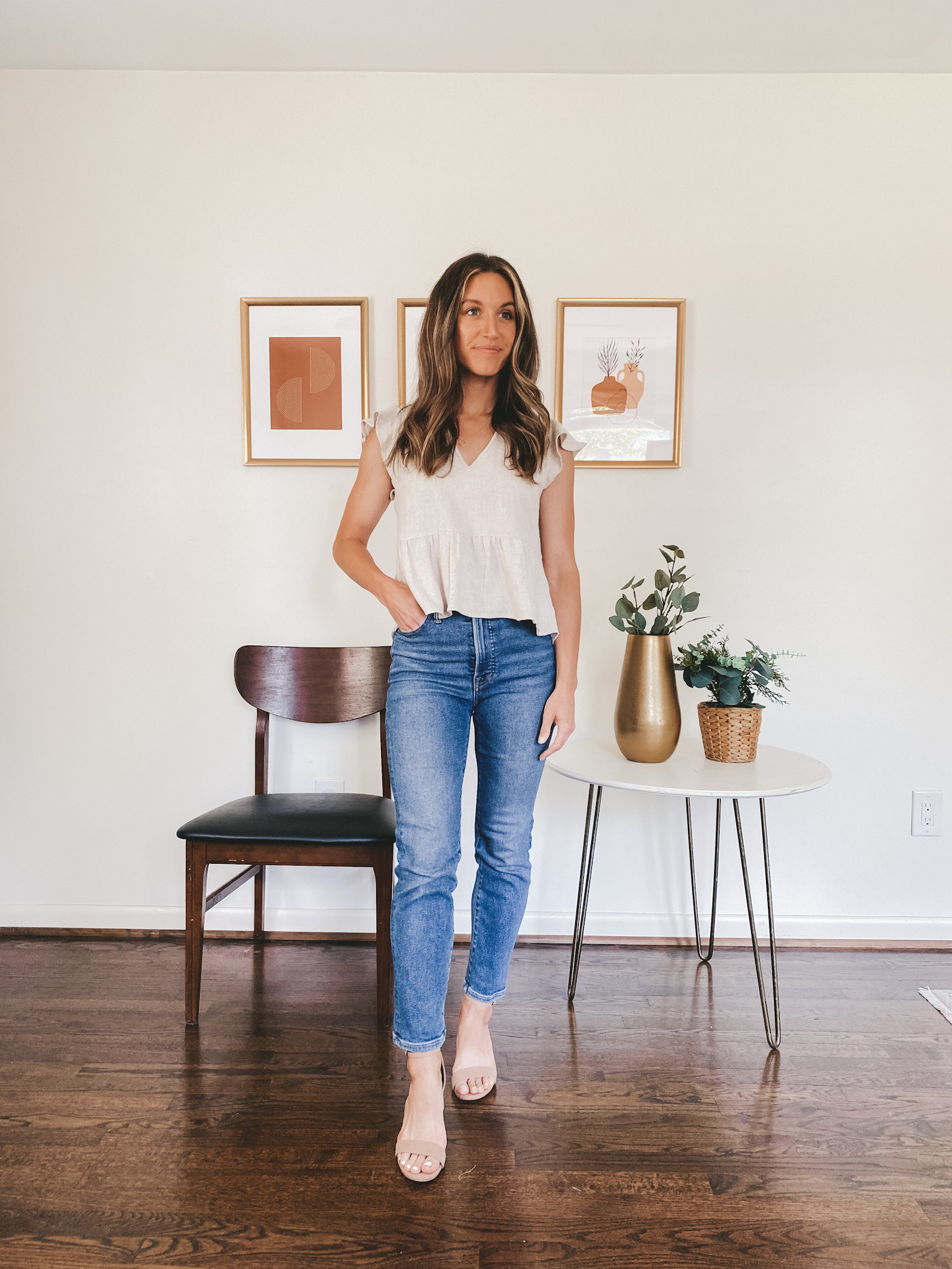 ashley wearing a tan linen blend flutter sleeve top, mid-wash straight leg denim and nude ankle strap block heels