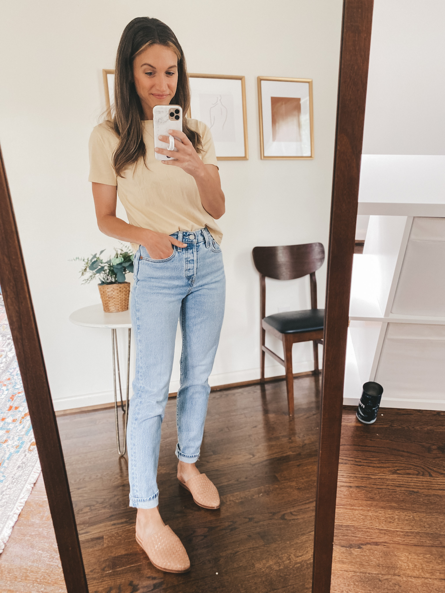 ashley wearing a tan short sleeved tee, light wash mom jeans and tan woven mules