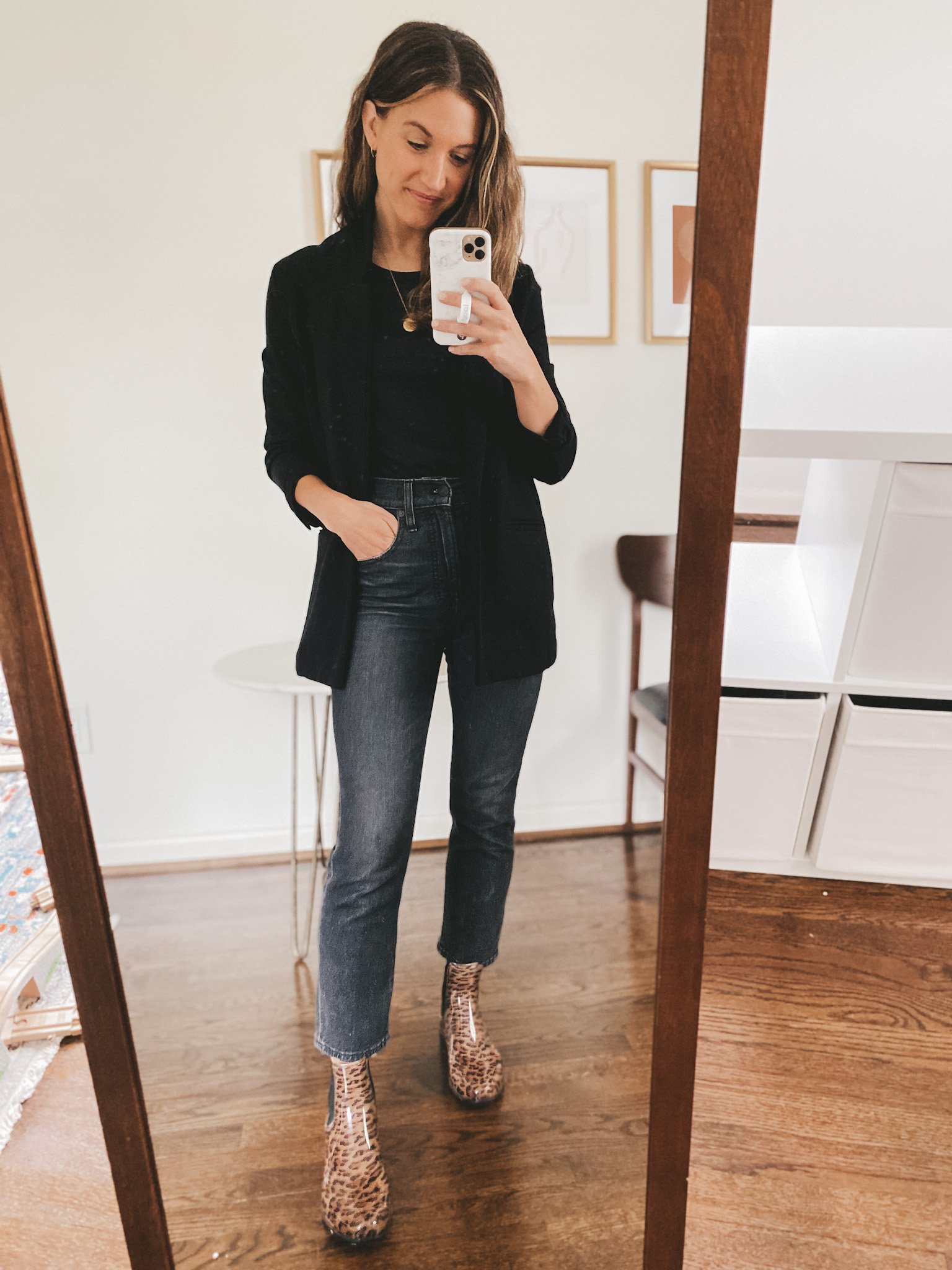 ashley wearing a black tank, black blazer, washed black jeans, and leopard print rainboots