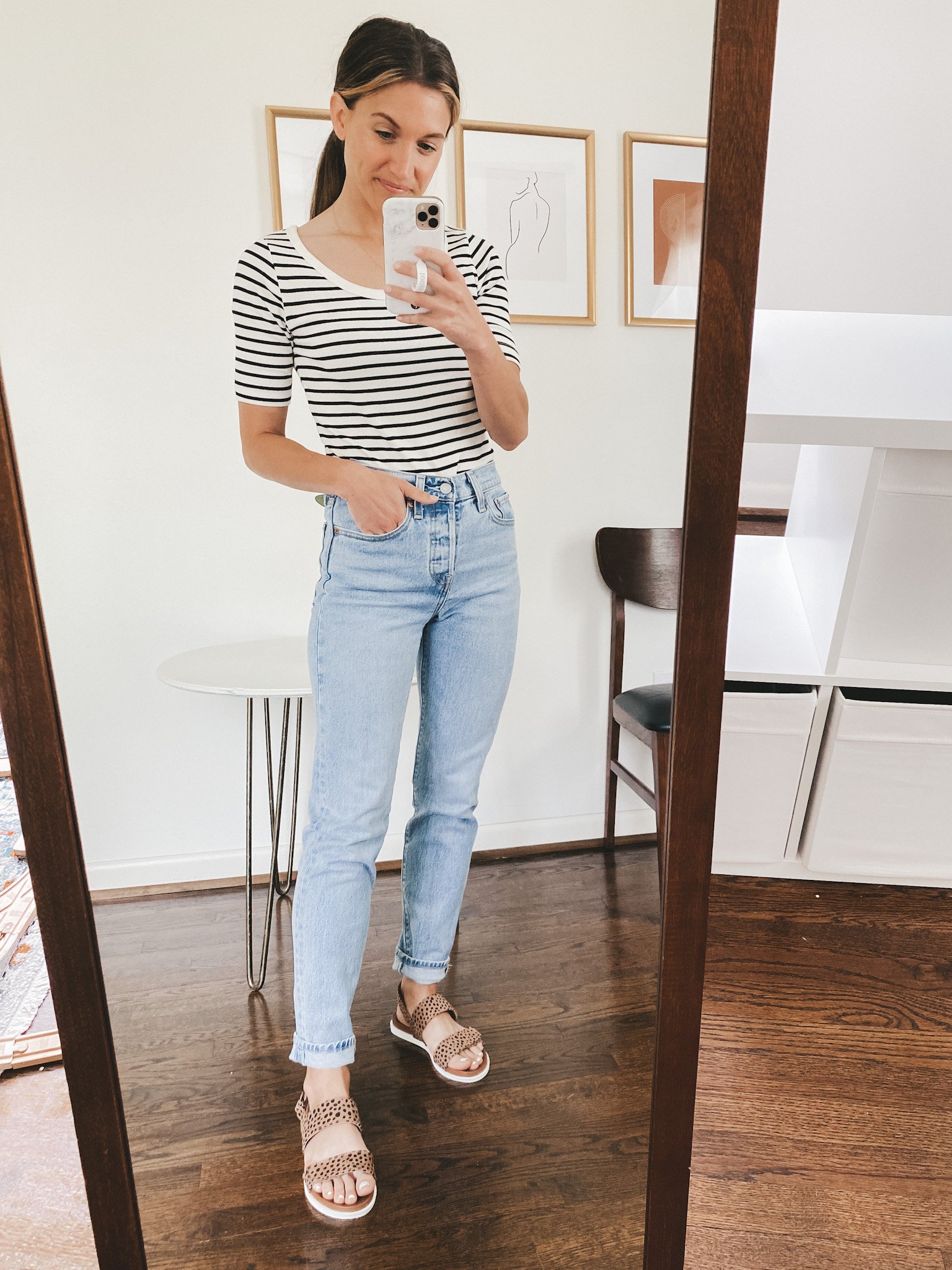 ashley wearing a fitted striped tee, light wash mom jeans and leopard print sandals