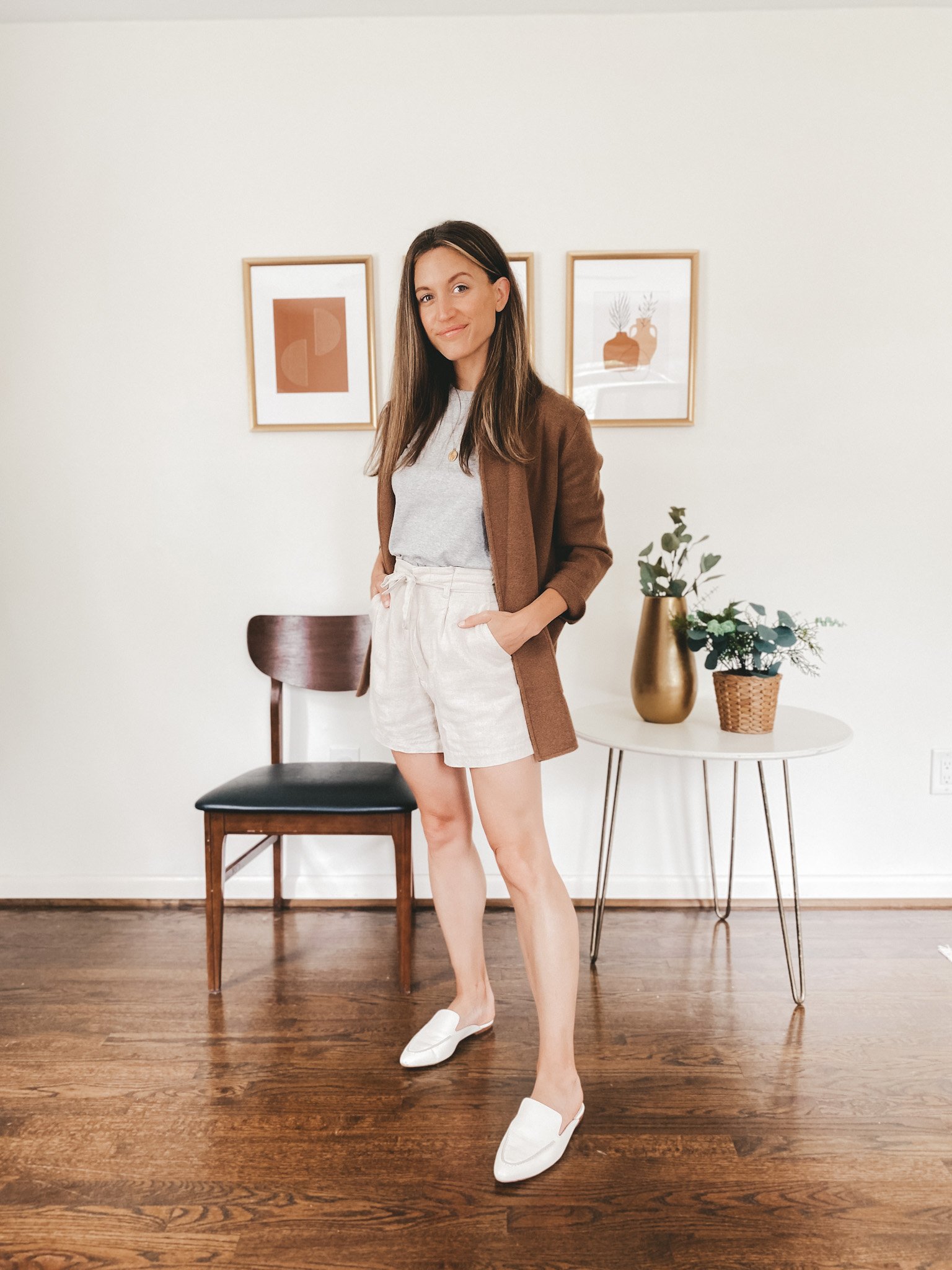 ashley wearing a gray tank, brown sweater blazer, tan linen shorts and white mules