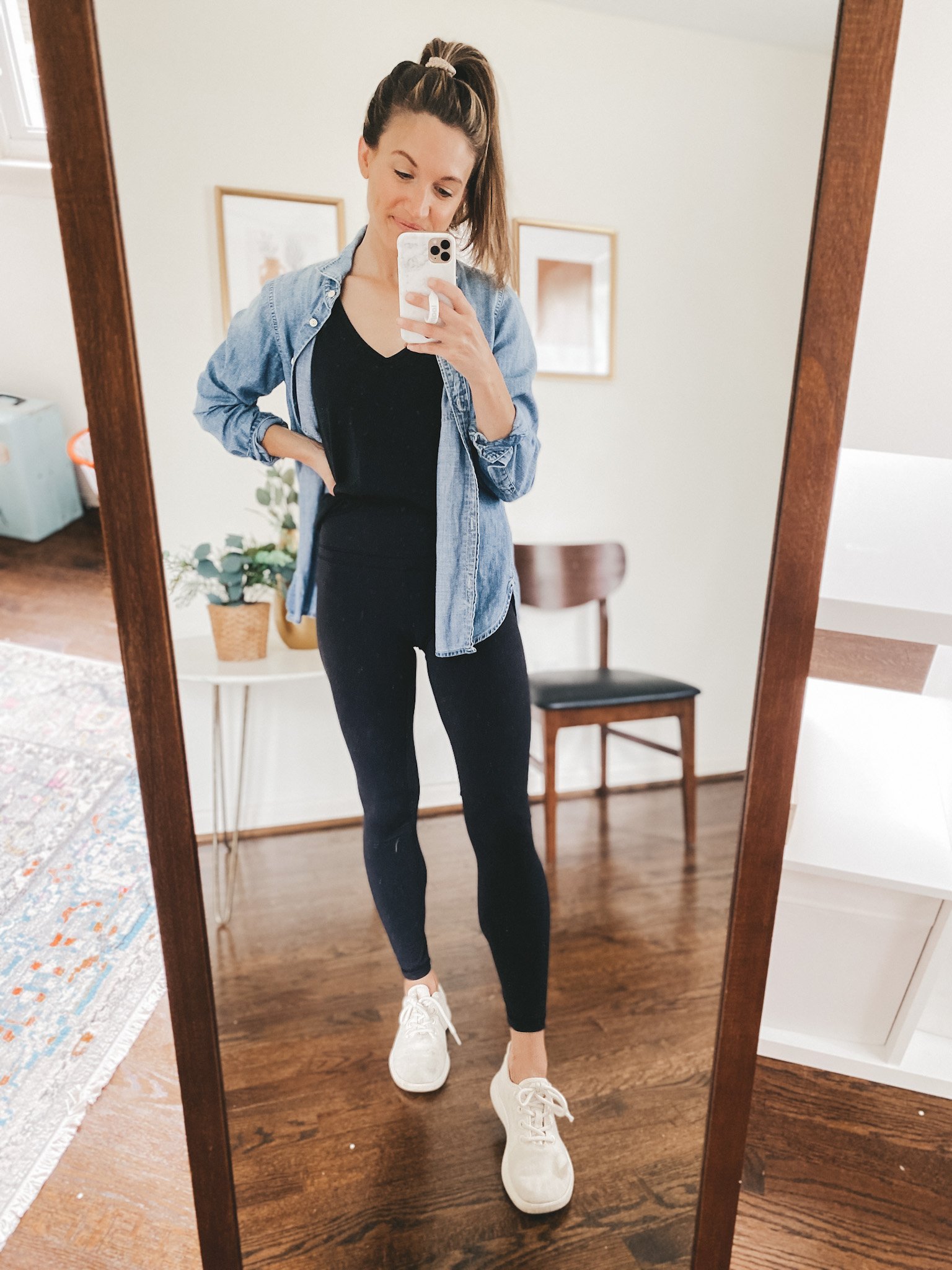 ashley wearing a black tank, chambray button down, black leggings and white wool runners