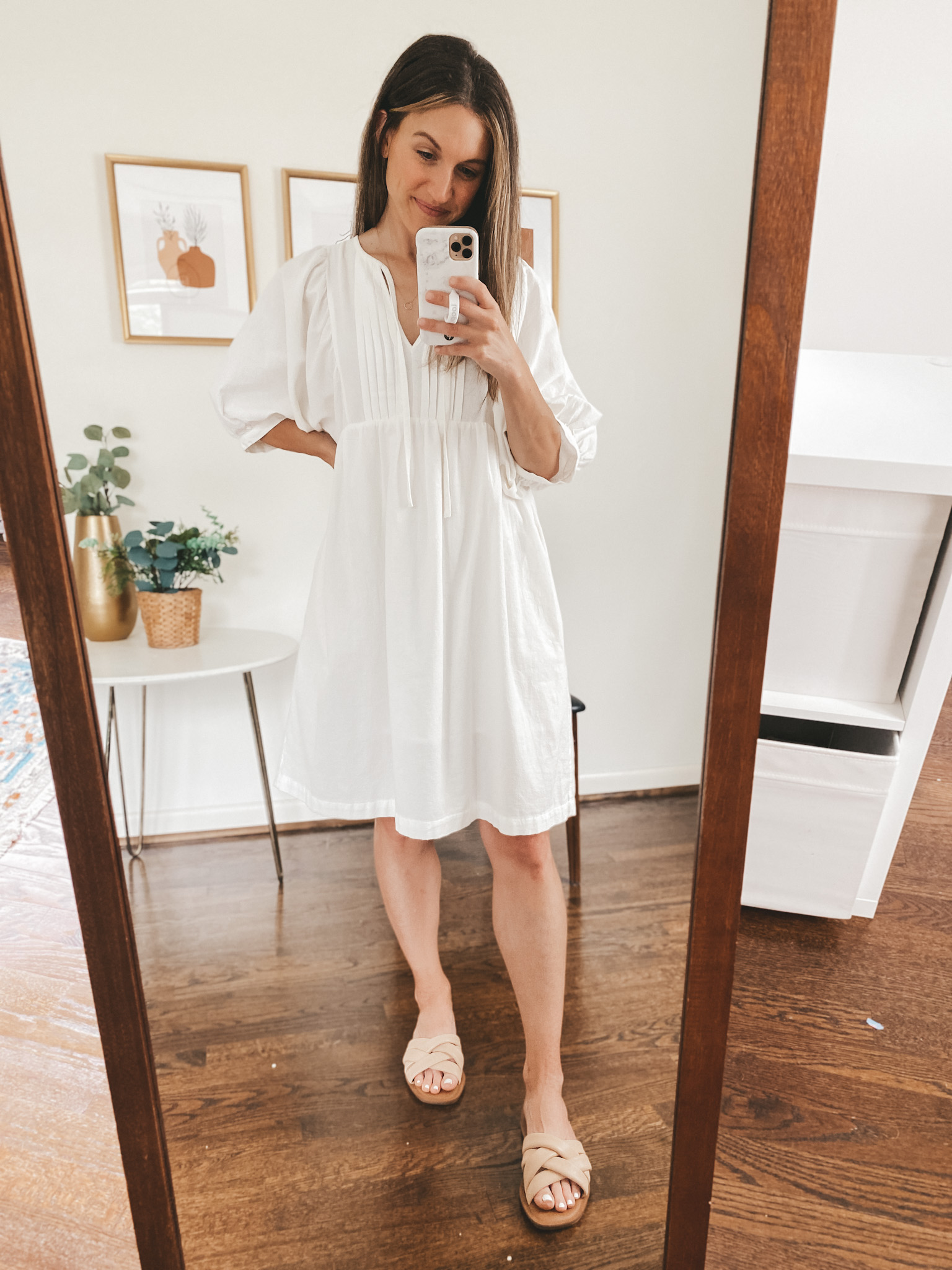 ashley wearing a white puff sleeve knee length dress and nude padded slides 