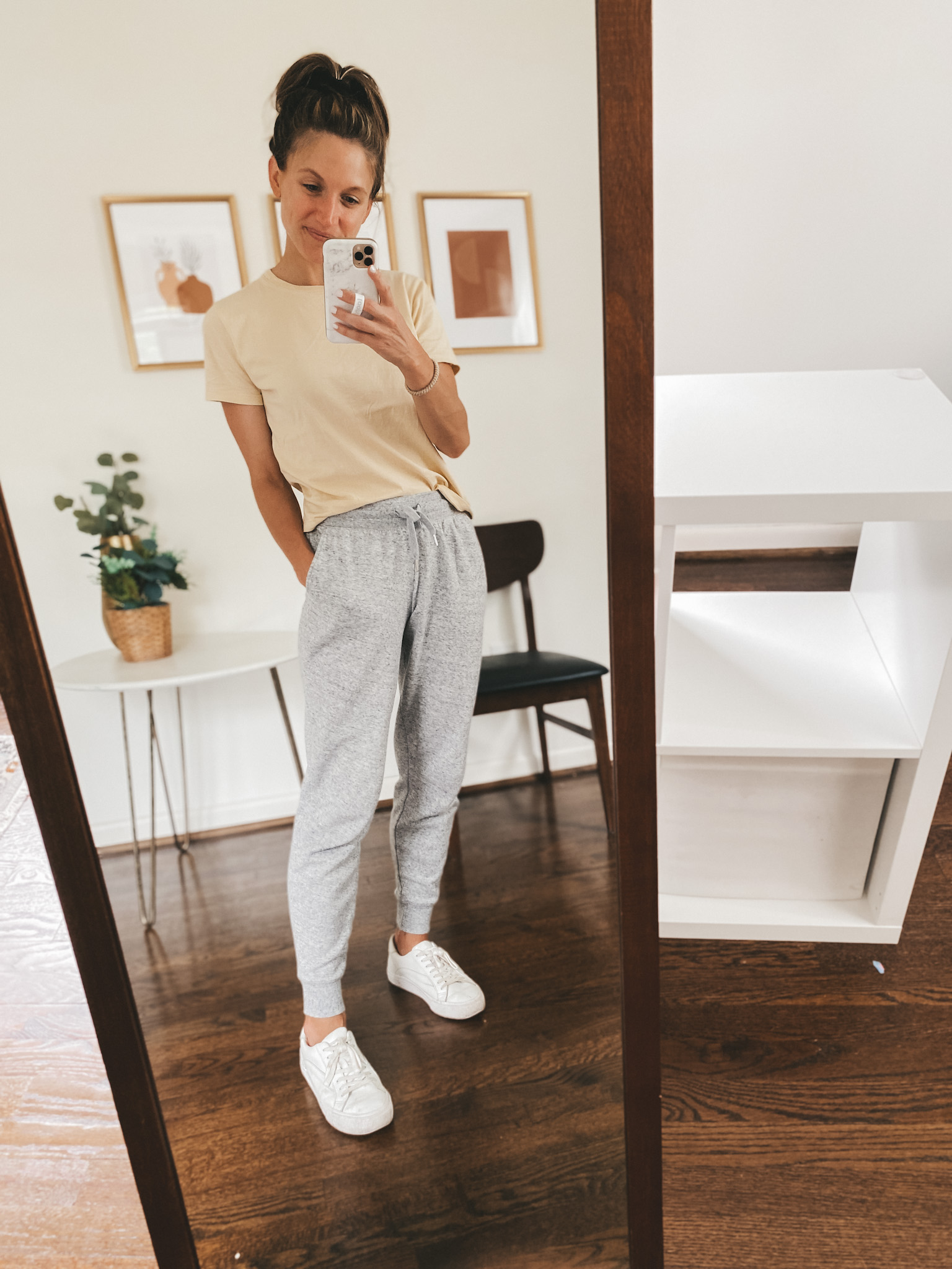 ashley wearing a tan short sleeved tee, gray joggers and white sneakers