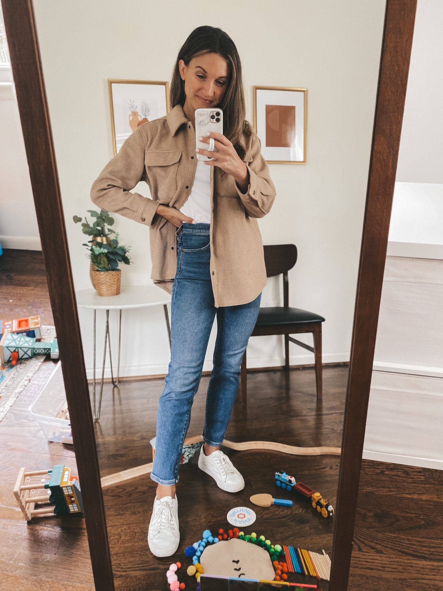 ashley wearing a white tank, tan shacket, mid-wash straight leg jeans and white sneakers