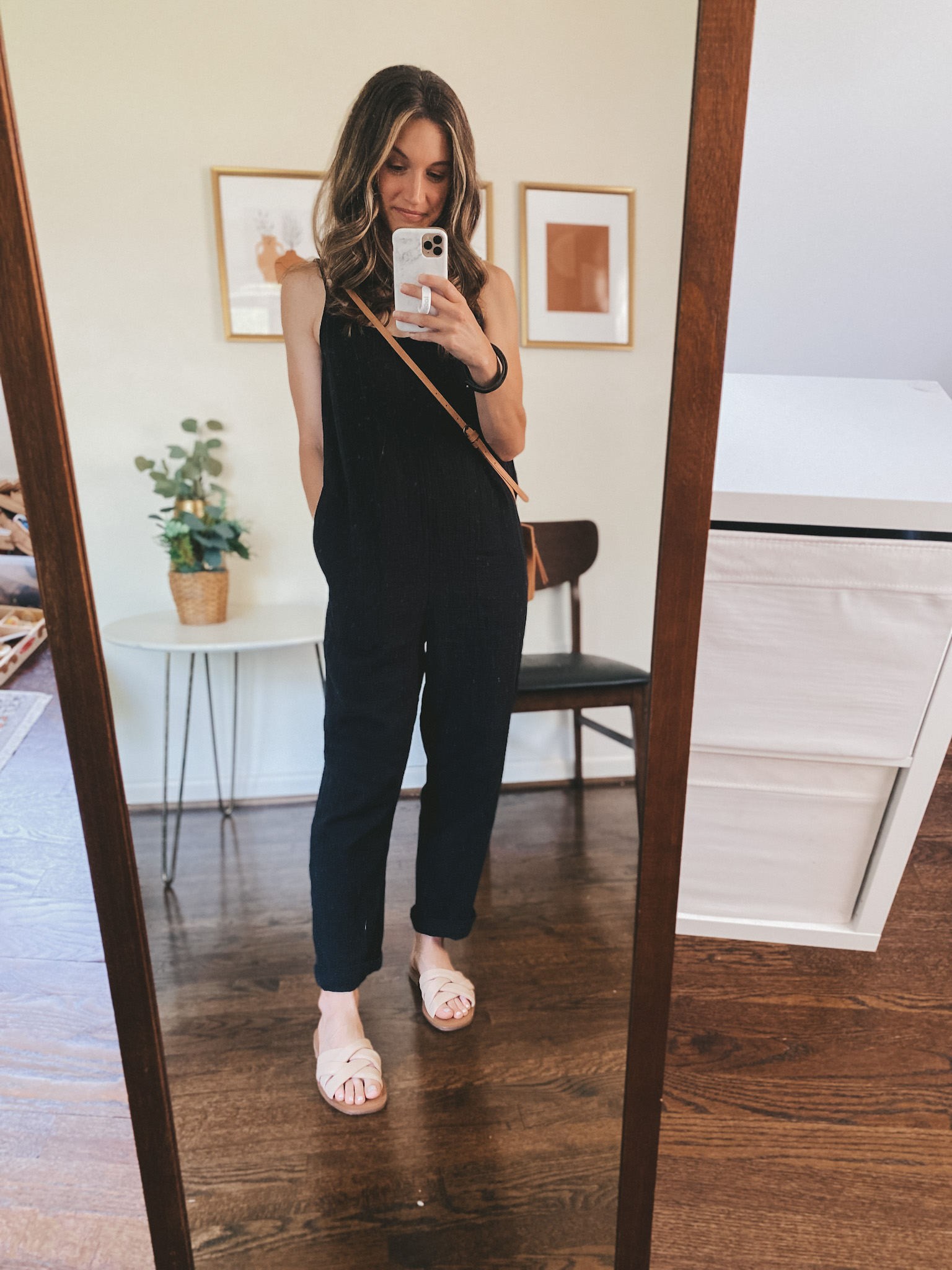 ashley wearing a black jumpsuit and nude padded slides