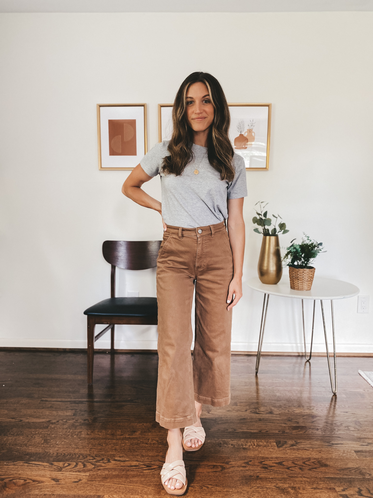 ashley wearing a gray tee, brown wide leg crop pants and nude padded slides