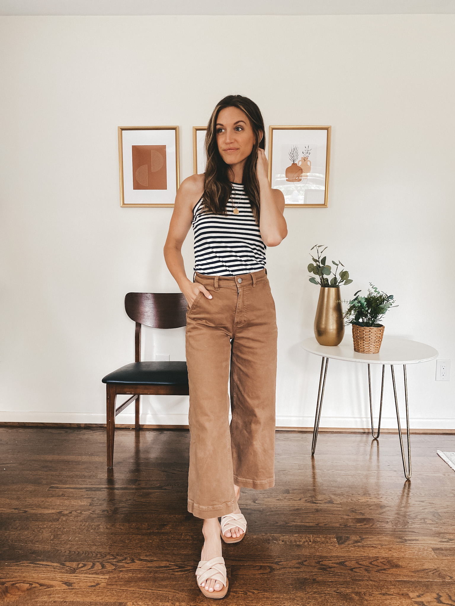 ashley wearing a navy and white striped tank, ochre wide leg crop pants and nude padded slides