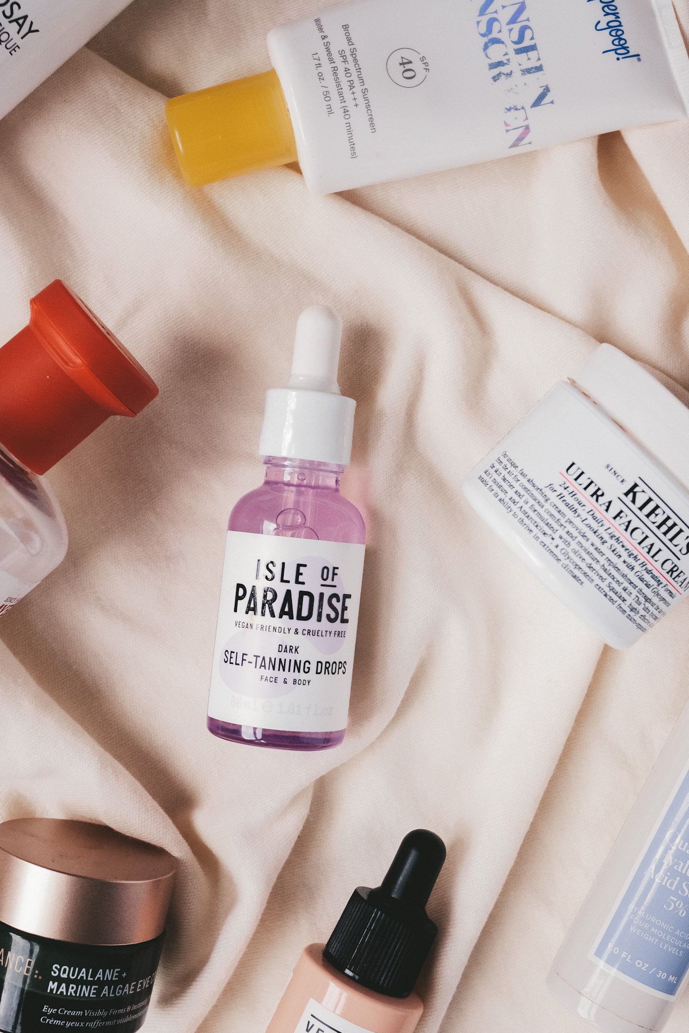 a cream colored fabric with various skincare products on it