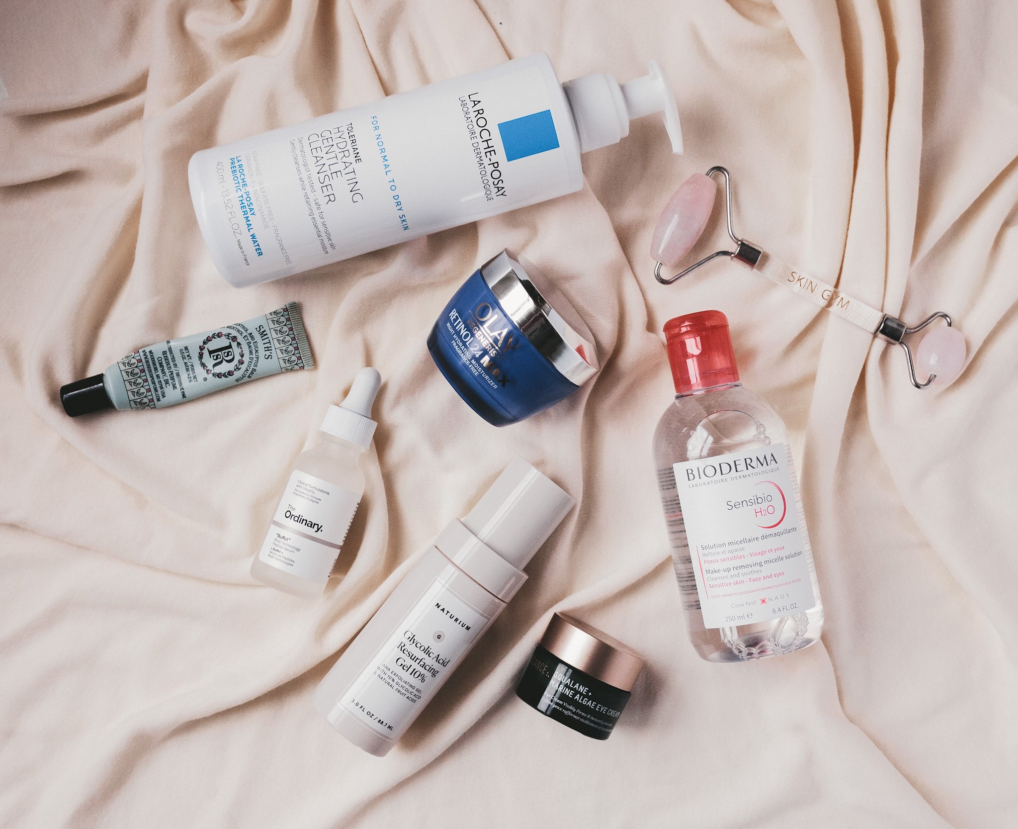 a cream colored fabric with various skincare products on it that are used as part of my summer skincare routine