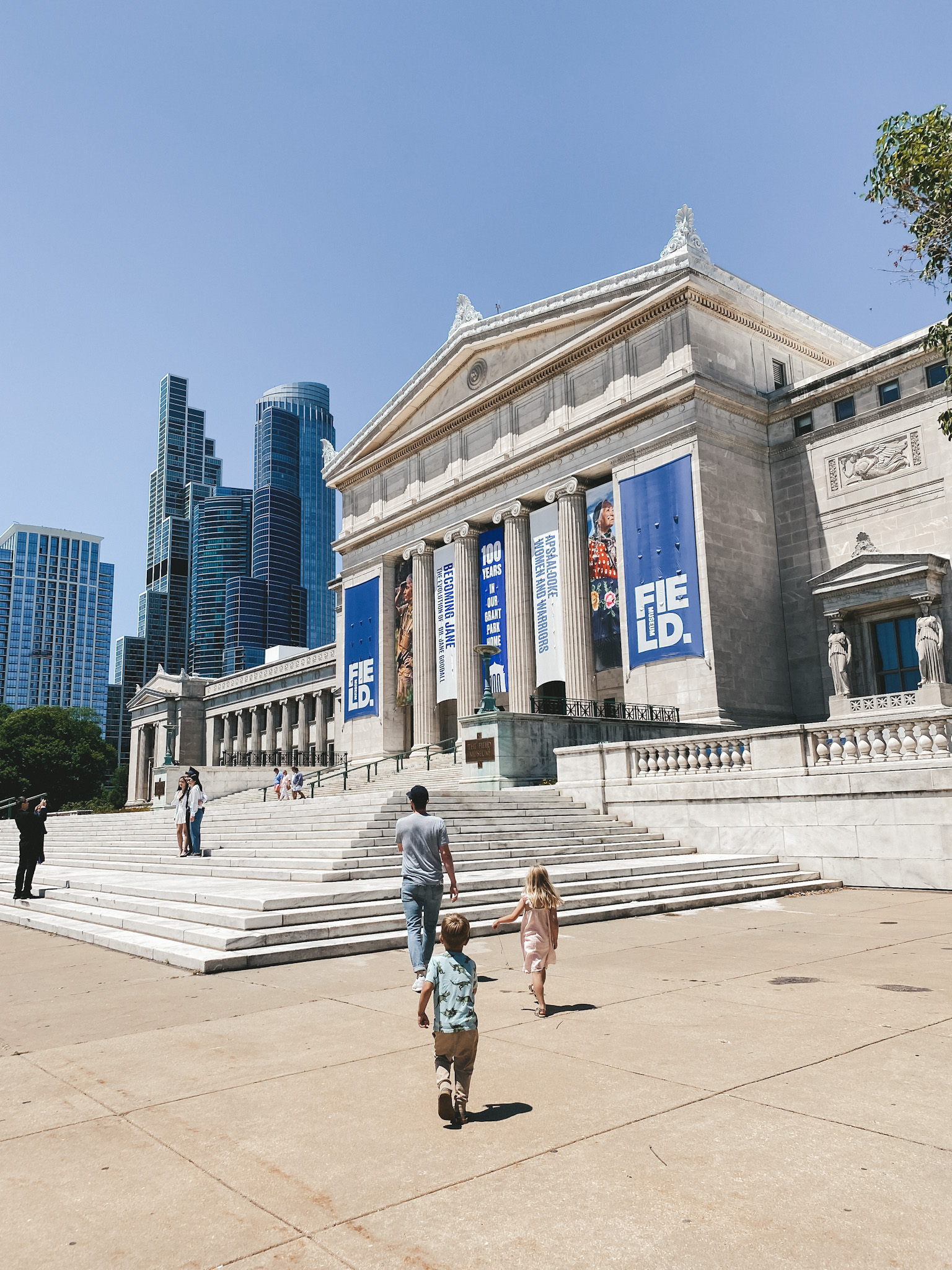 a dad and two kids walking into the Field Museum in Chicago