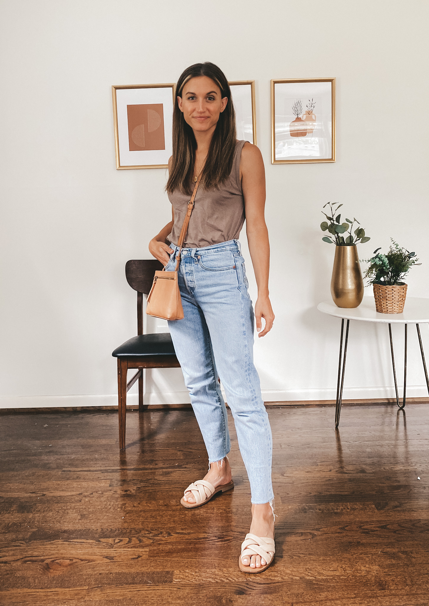 ashley wearing a taupe tank, light wash jeans and nude padded slides