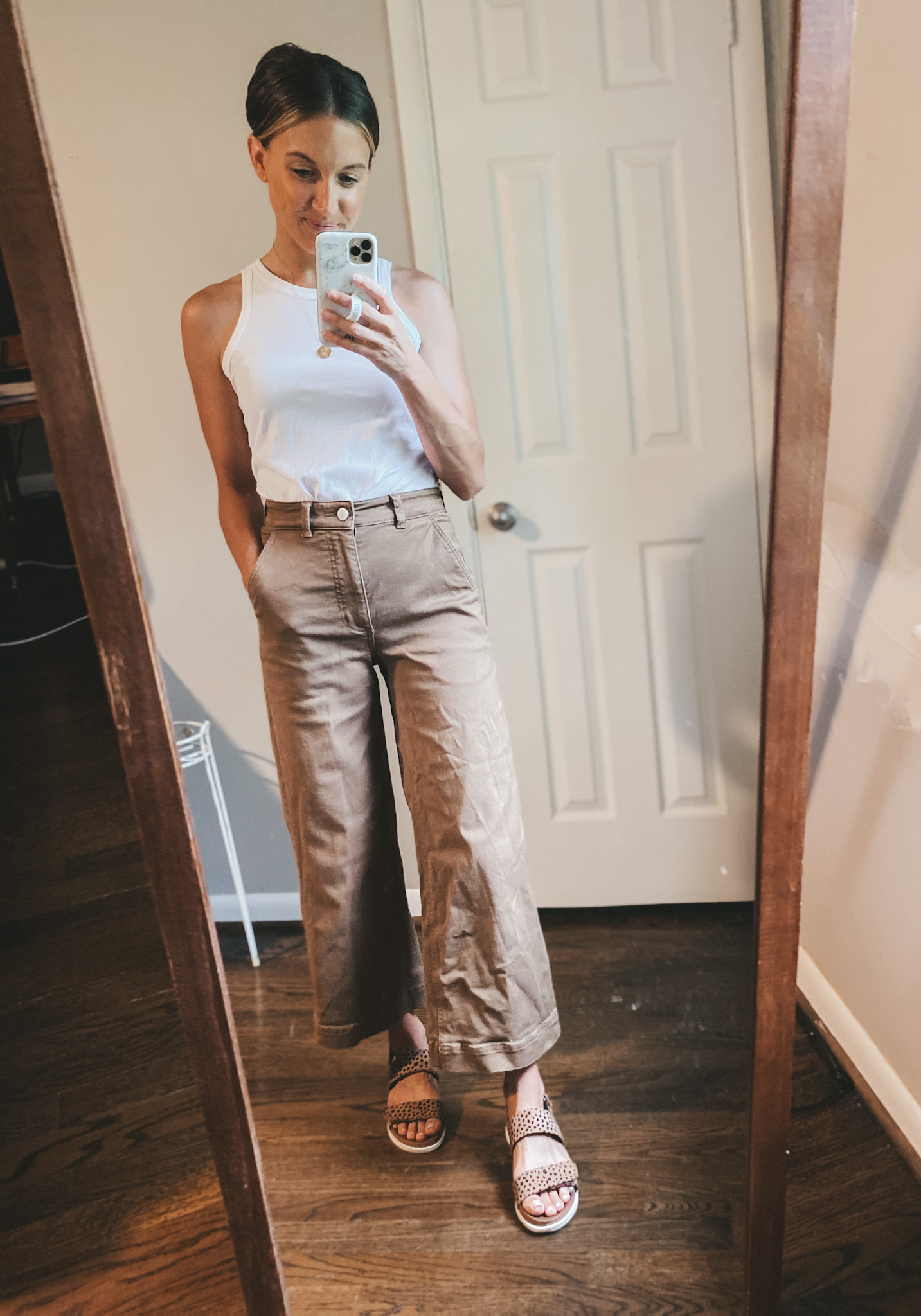 ashley wearing a white tank, brown wide leg cropped pants, and leopard print sandals
